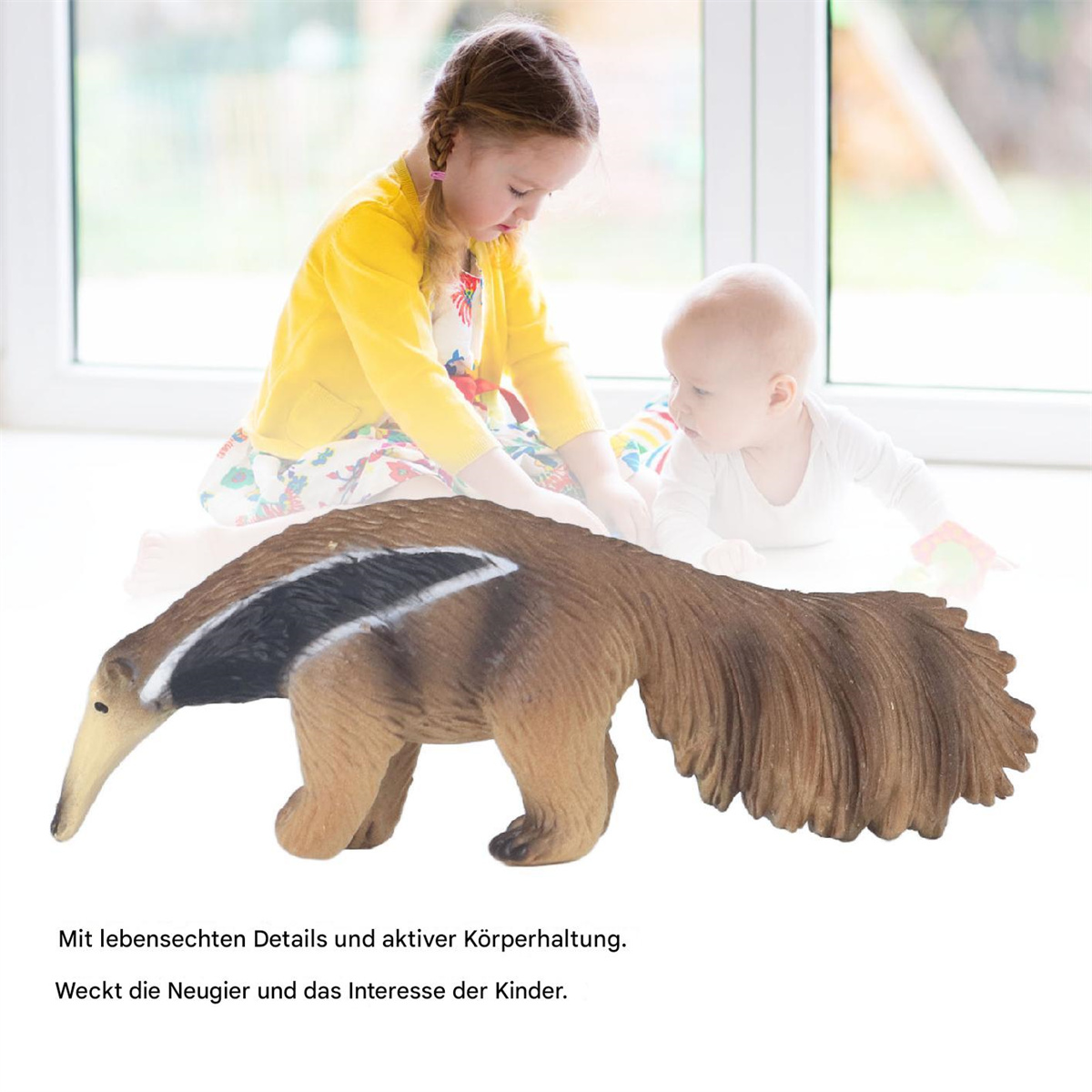 Ein Spielzeug-Ameisenbär vor zwei Kindern. Der Ameisenbär hat eine lange Schnauze und einen großen Schwanz.
