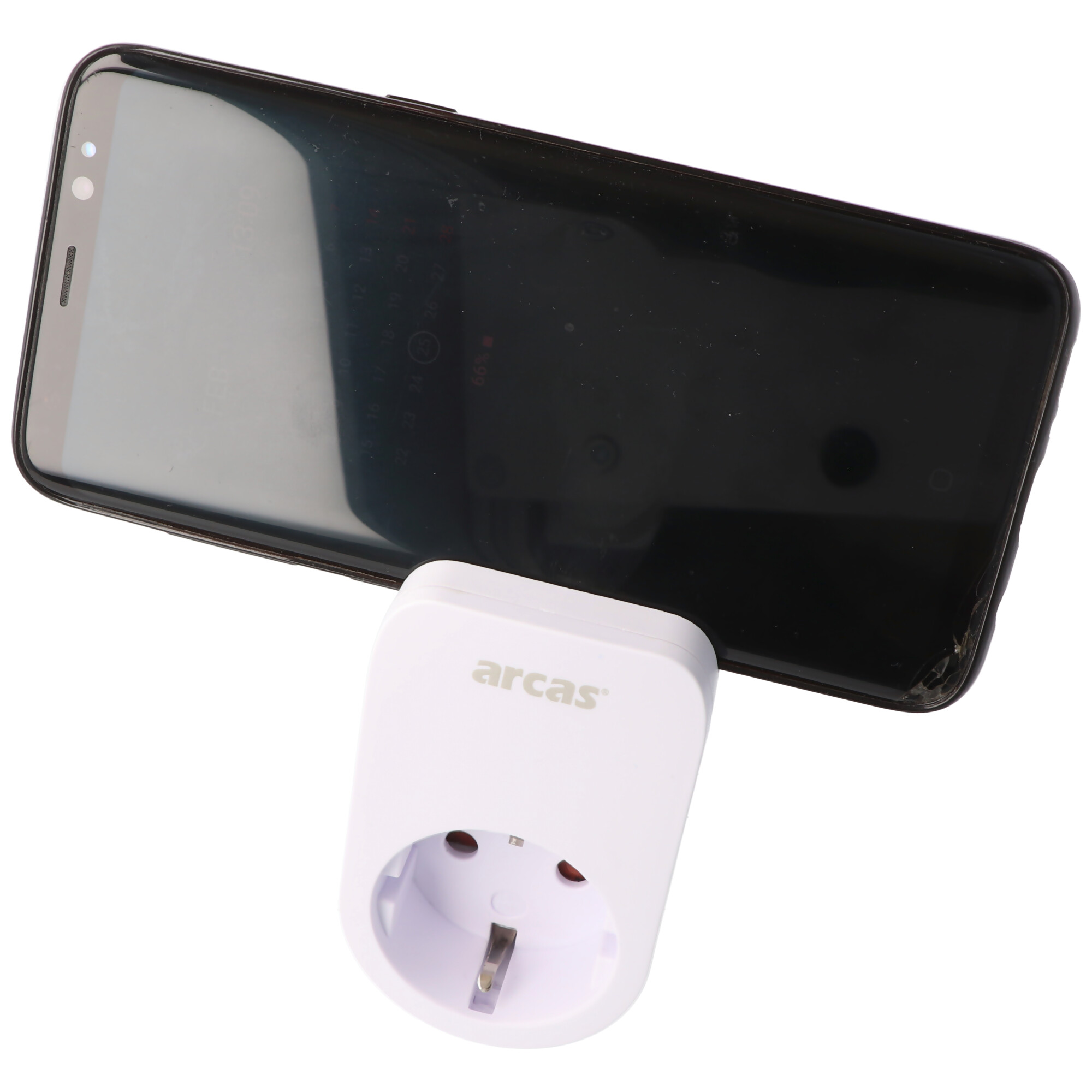 Witte Arcas stekkeradapter naast een zwarte smartphone.