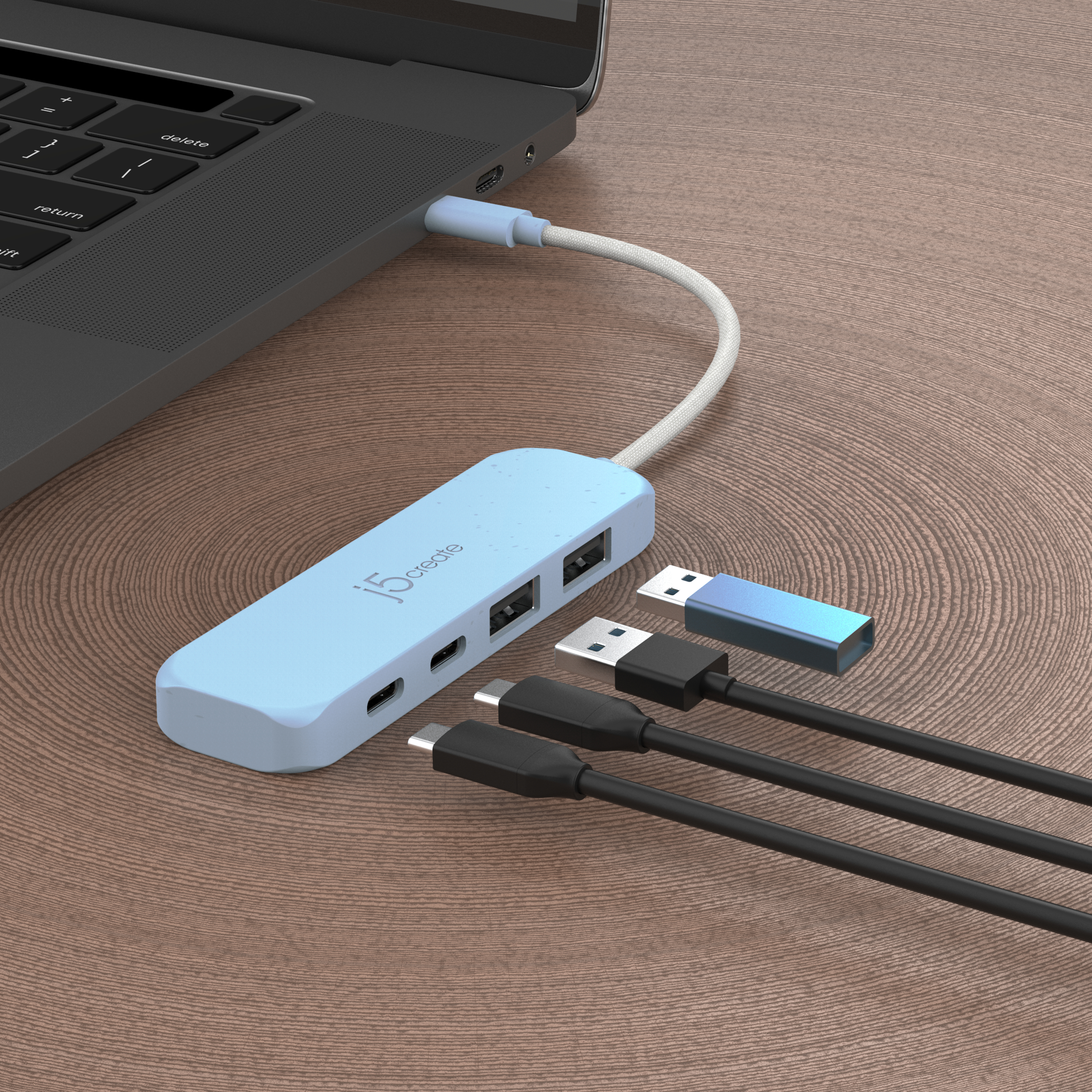 Laptop mit einem hellblauen Hub mit USB-Anschlüssen und USB-Geräten verbunden.