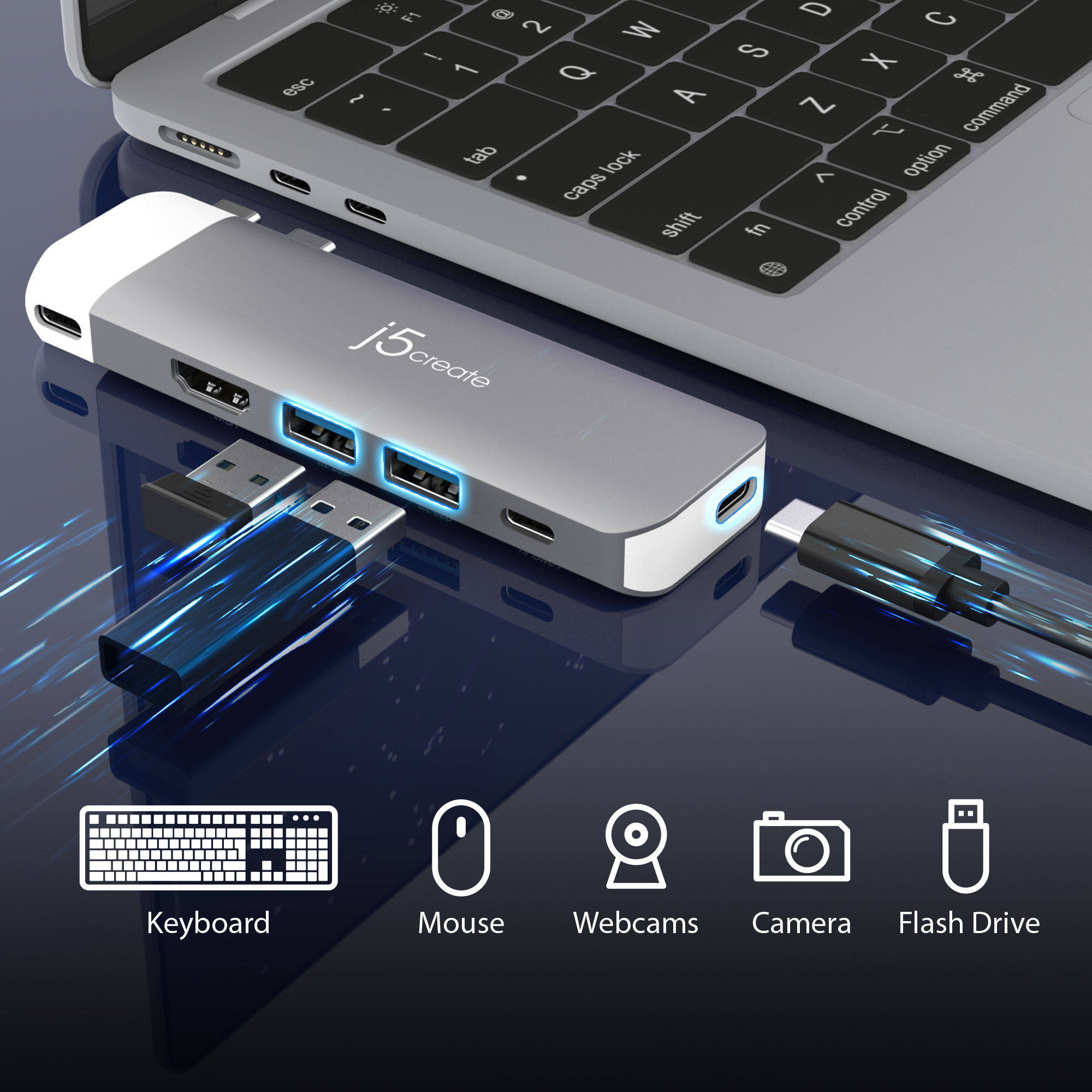 Laptop con hub USB grigio, collegato a tastiera, mouse, webcam, fotocamera e chiavetta USB.