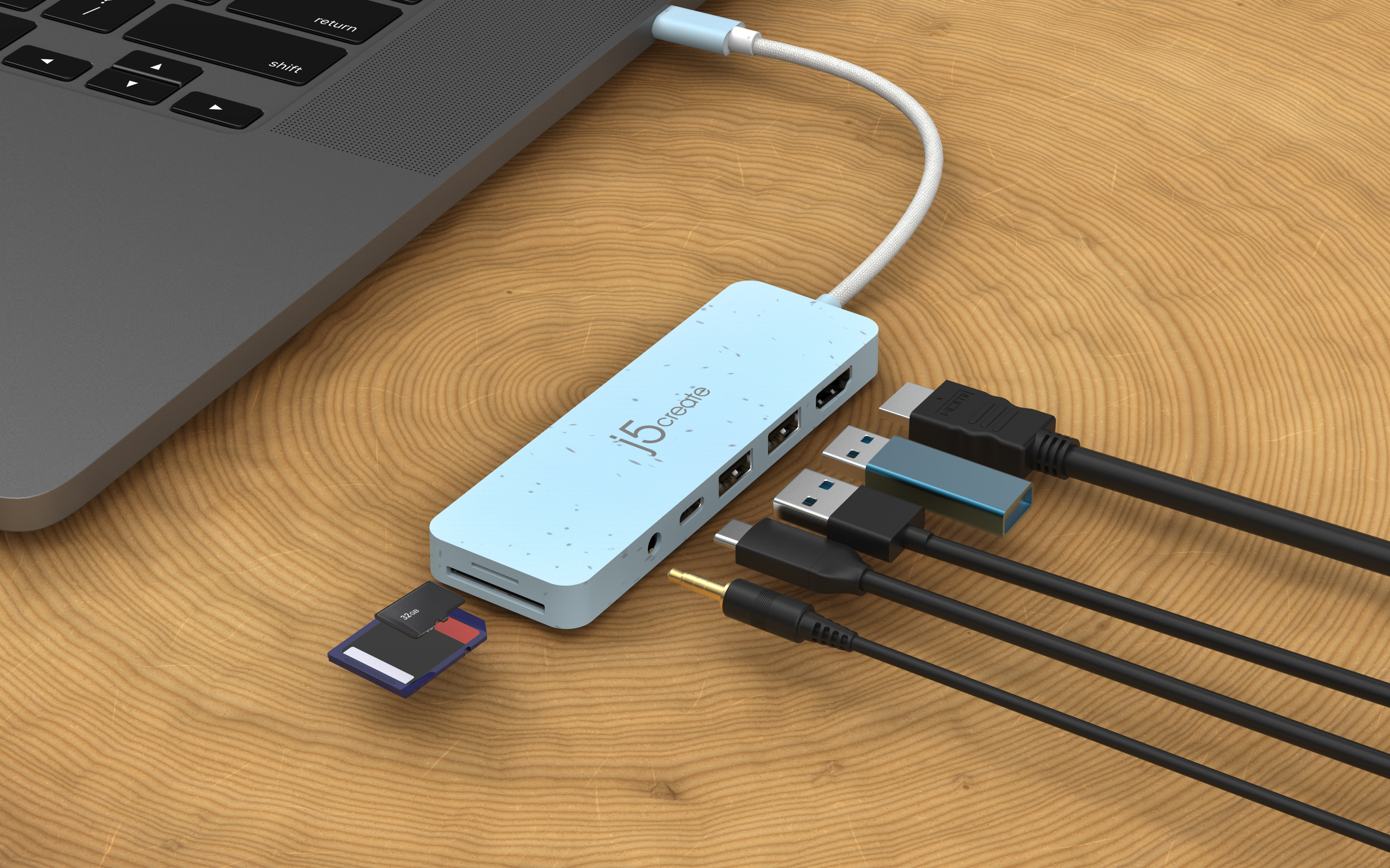 Hub blu con più cavi collegati a un laptop su una superficie di legno.