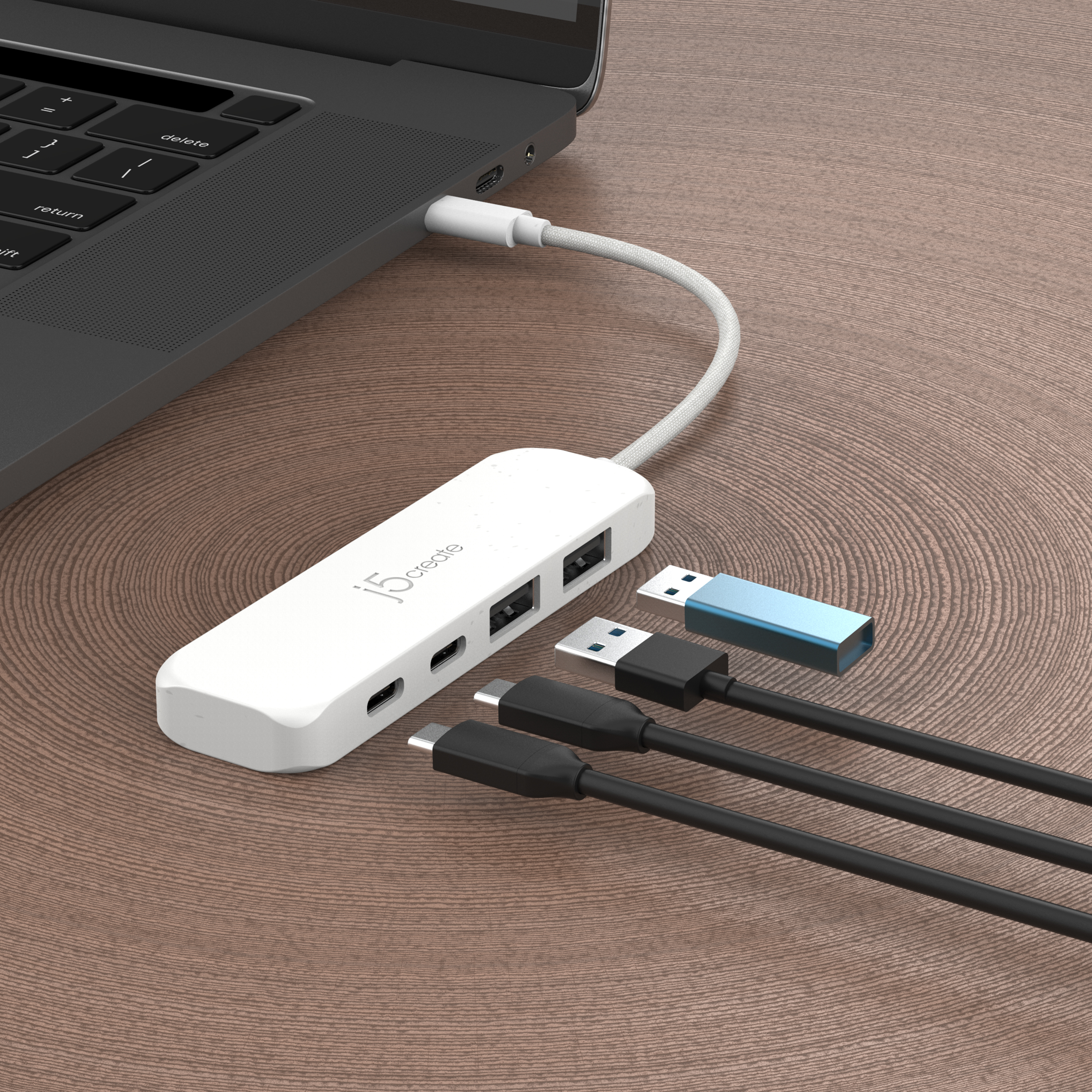 Laptop, der mit einem weißen USB-Hub mit mehreren Anschlüssen verbunden ist. USB-Laufwerk sichtbar.