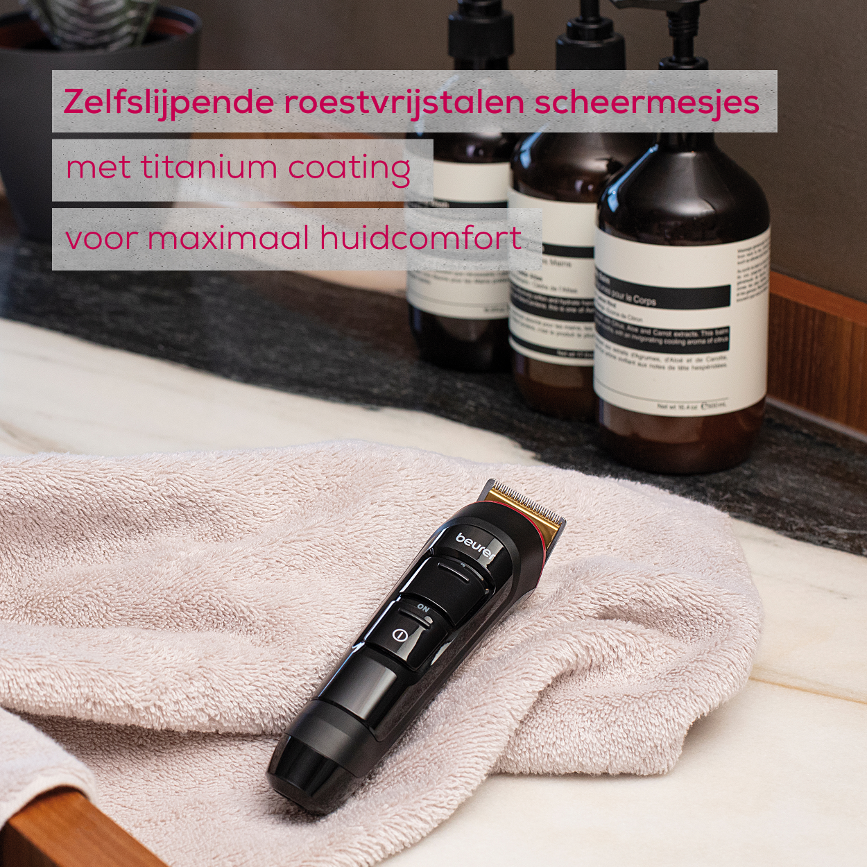 Een zwarte elektrische trimmer met titanium coating en zelf slijpende messen. Hij ligt op een handdoek.
