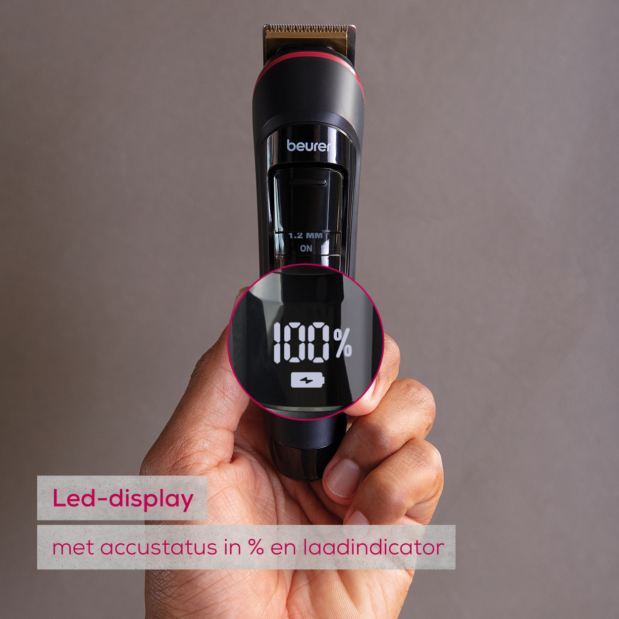 Haartrimmer met LED-display met 100% lading. Hand houdt de trimmer vast.