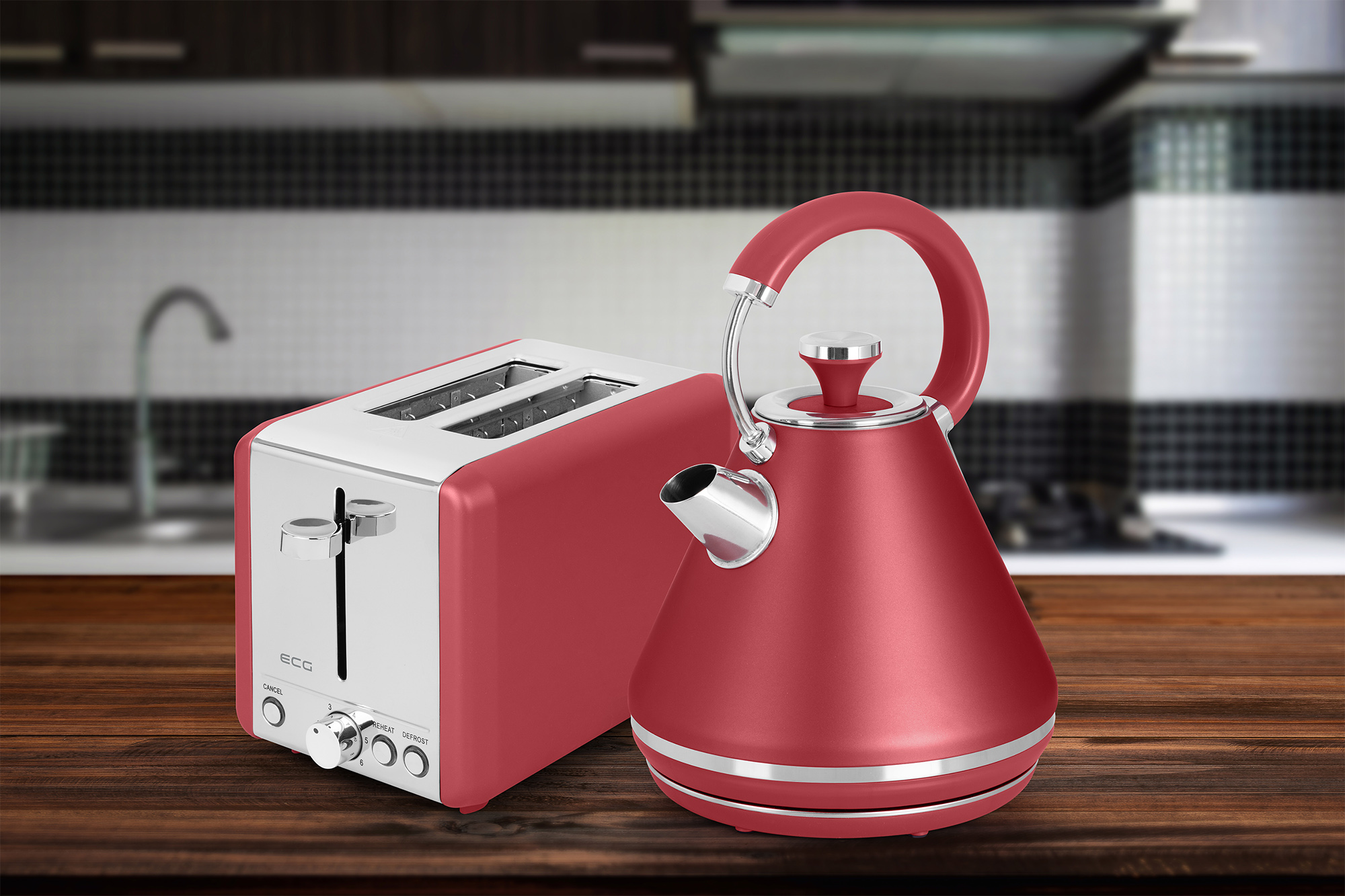 Roter Toaster und Wasserkocher auf Holzoberfläche, mit verschwommenem Küchenhintergrund.