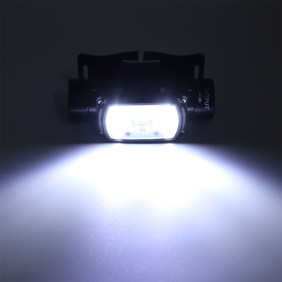 Eine Stirnlampe, die ein helles weißes Licht auf eine Oberfläche scheint. Die Lampe ist schwarz.
