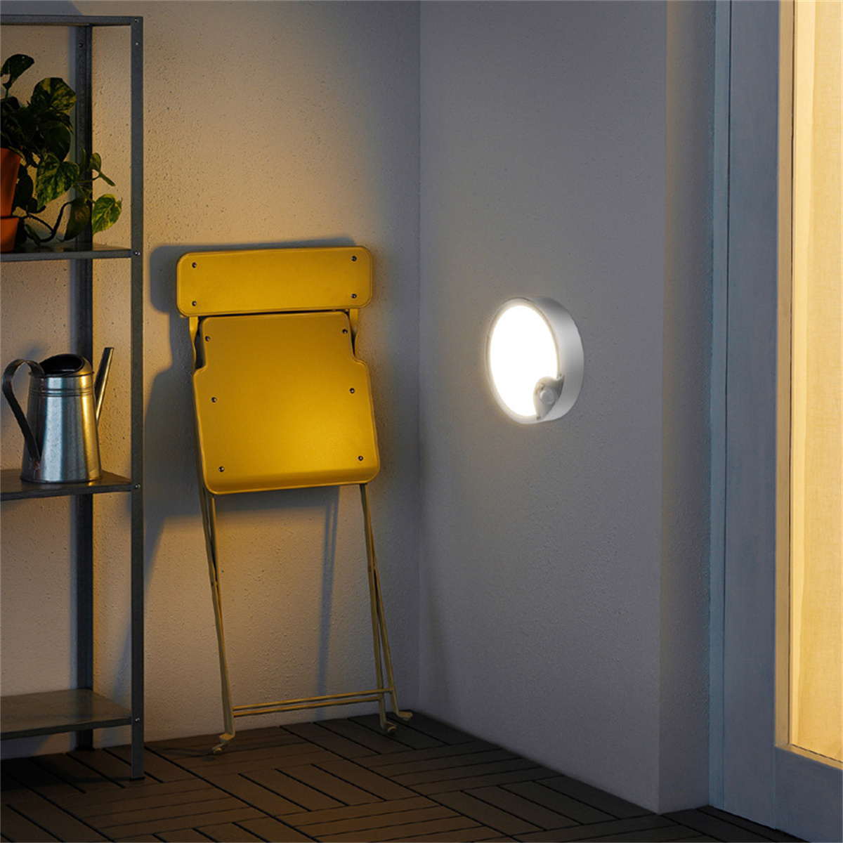 Eine Wand mit Licht und Stuhl. Das Licht ist ein kleiner Kreis. Ein Stuhl steht vor der Wand.