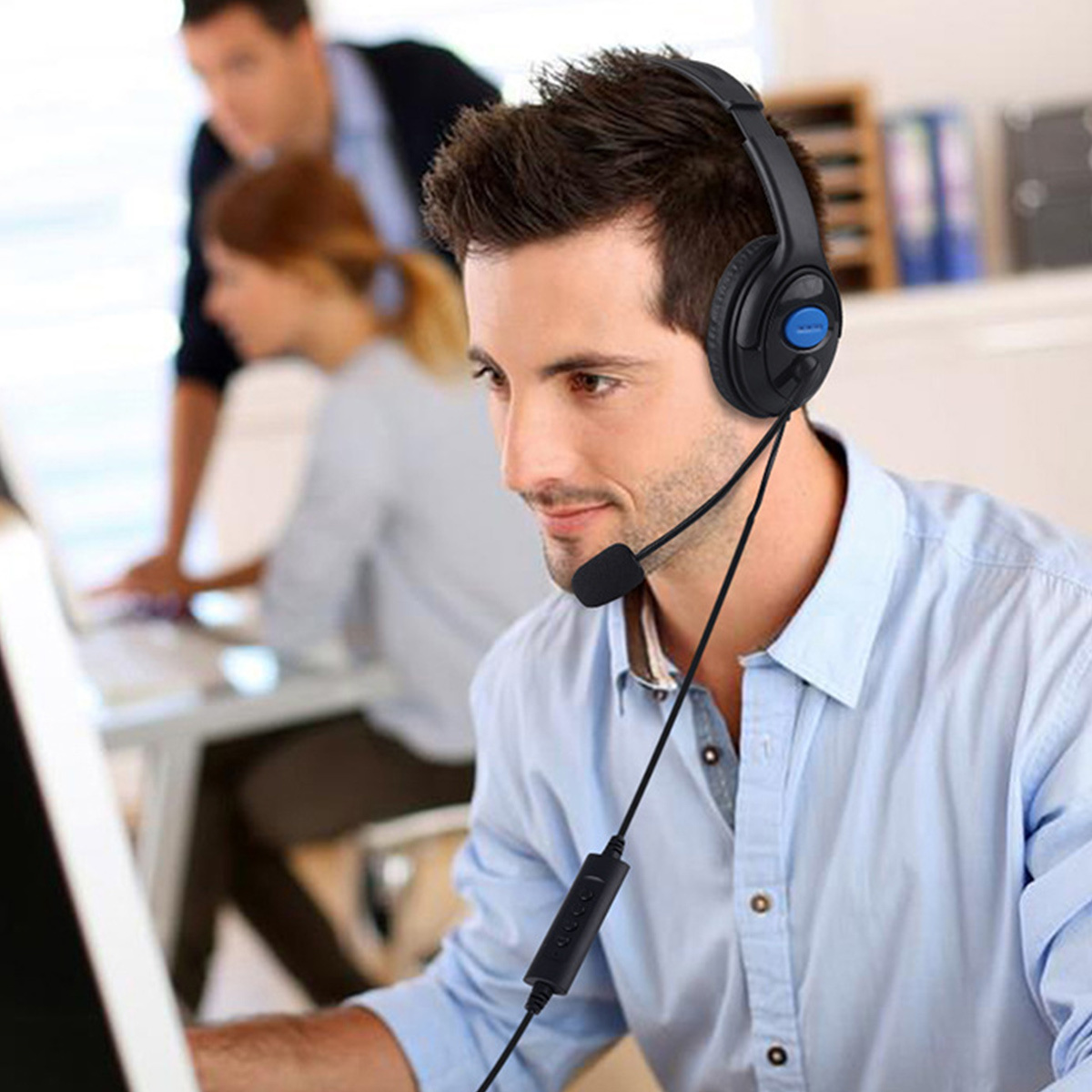 Ein Mann mit Headset, der in einem Büro an einem Computer arbeitet.