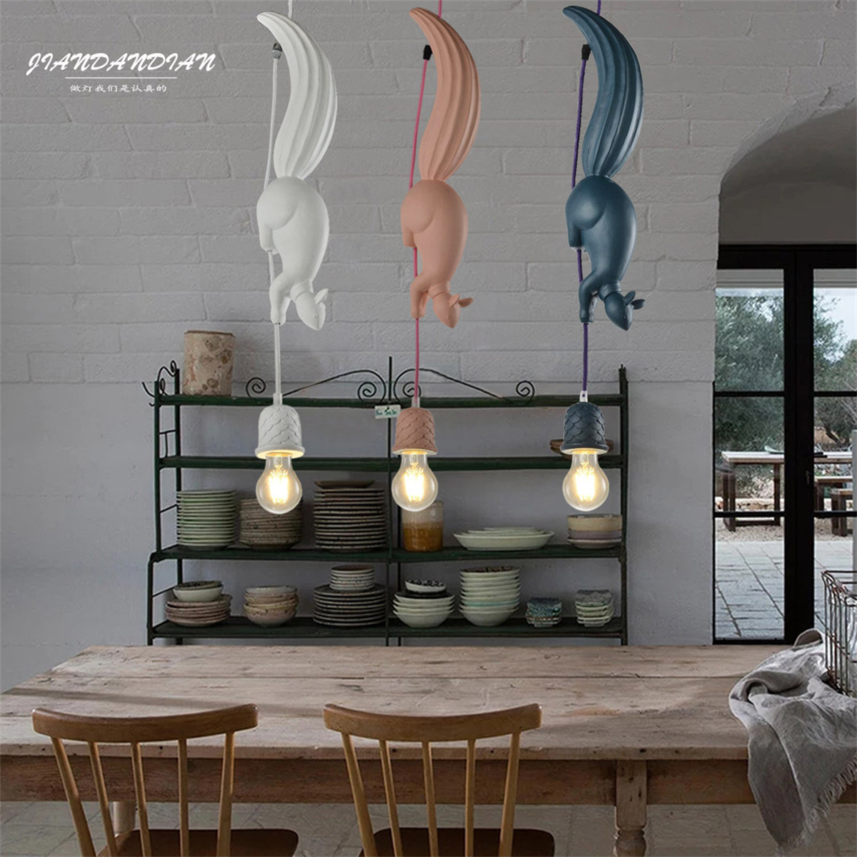 Eichhörnchenförmige Lampen über einem Tisch. Weiße, rosa und blaue Eichhörnchen mit Glühbirnen.