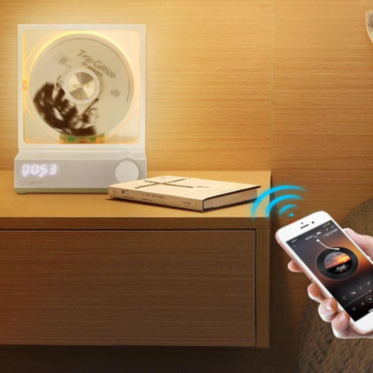 Ein CD-Player mit einer CD darin, neben einem Buch und einem Smartphone.