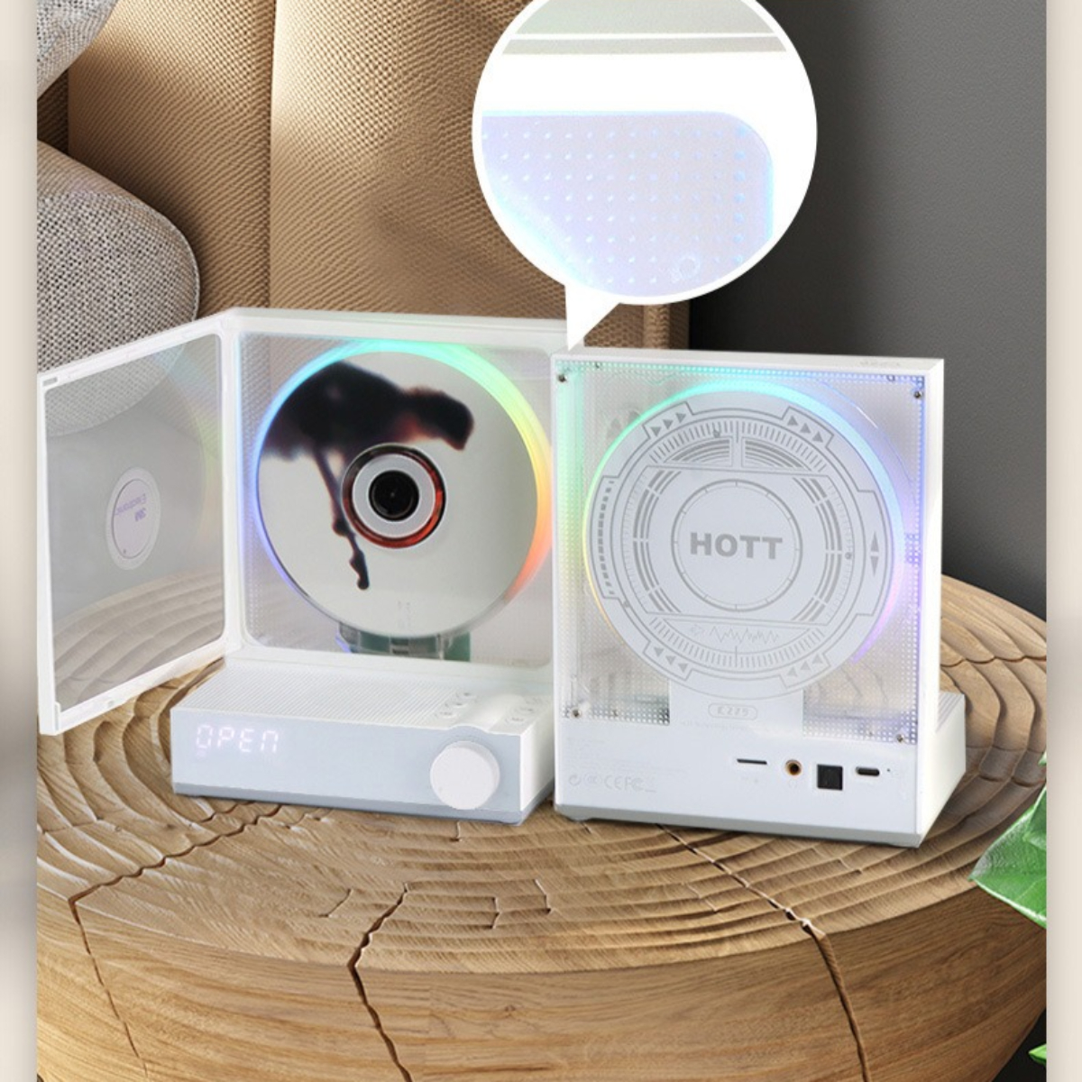 Weißer CD-Player mit offenem Deckel, CD innen und kleinem Bildschirm. Auf einem Holztisch.