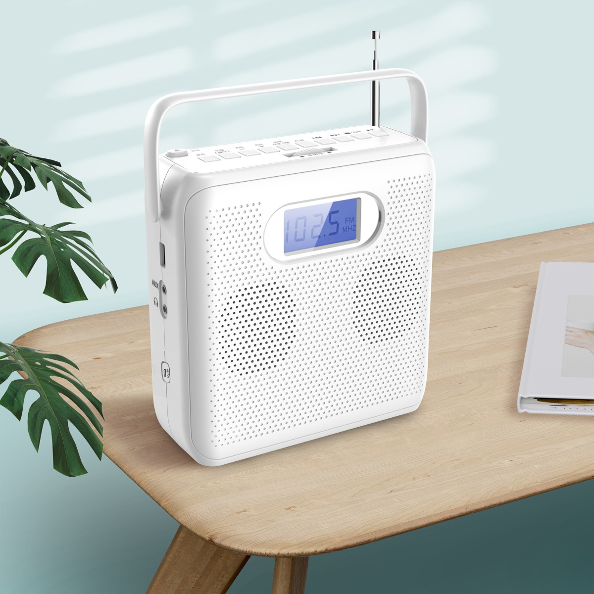 Weißes Radio mit Griff, Knöpfen und Bildschirm auf einem Holztisch.