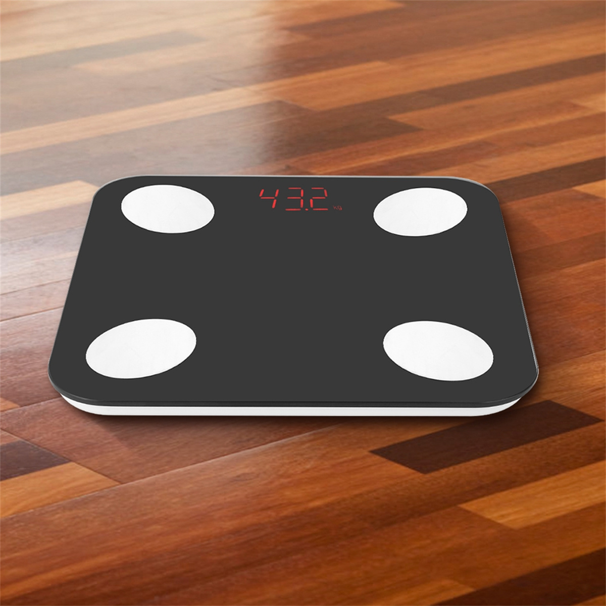 Schwarze Digitalwaage auf Holzboden, zeigt 43,2 kg an.