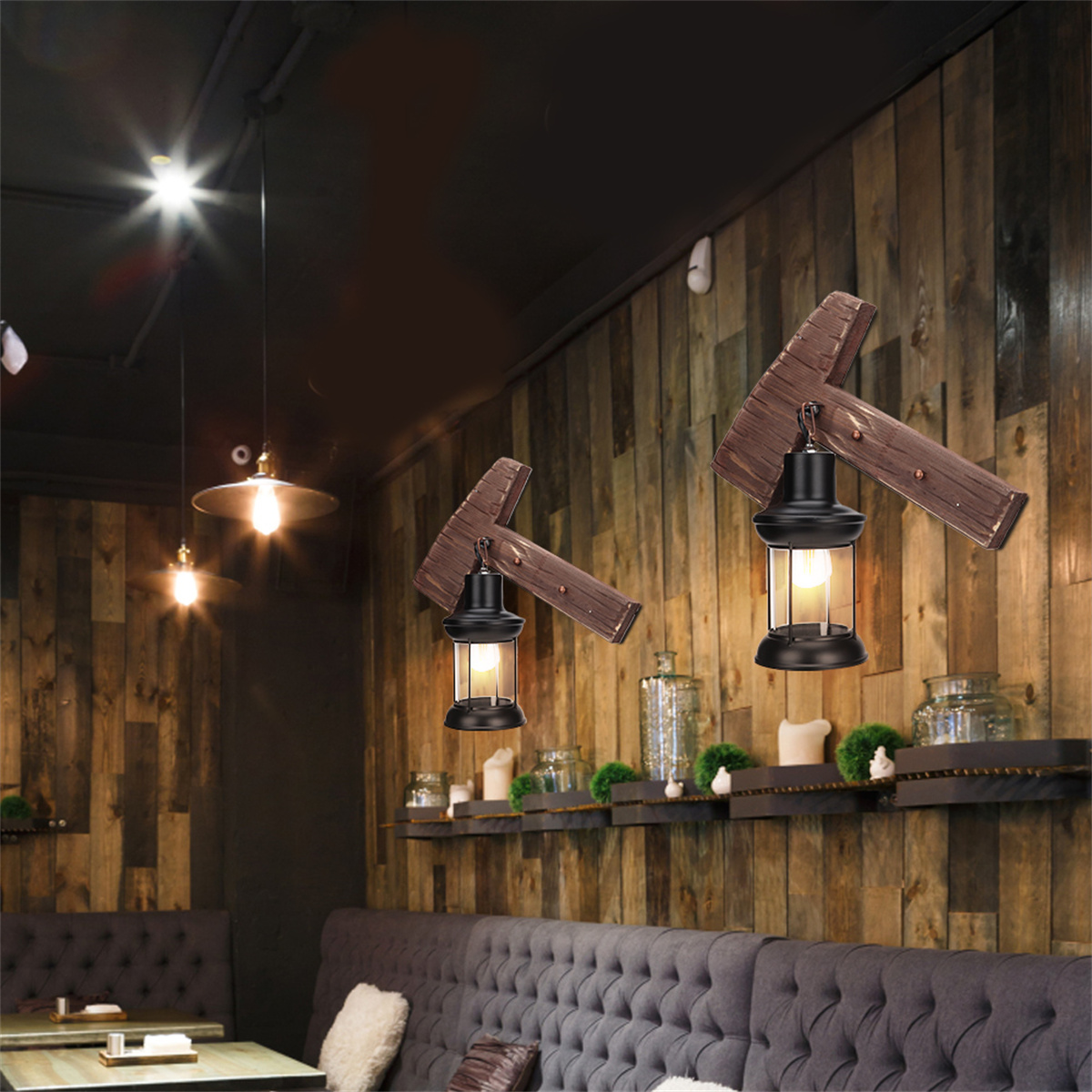 Eine Restaurantszene mit einer Holzwand, Wandlampen und einem grauen Sofa. Drei Lampen hängen.
