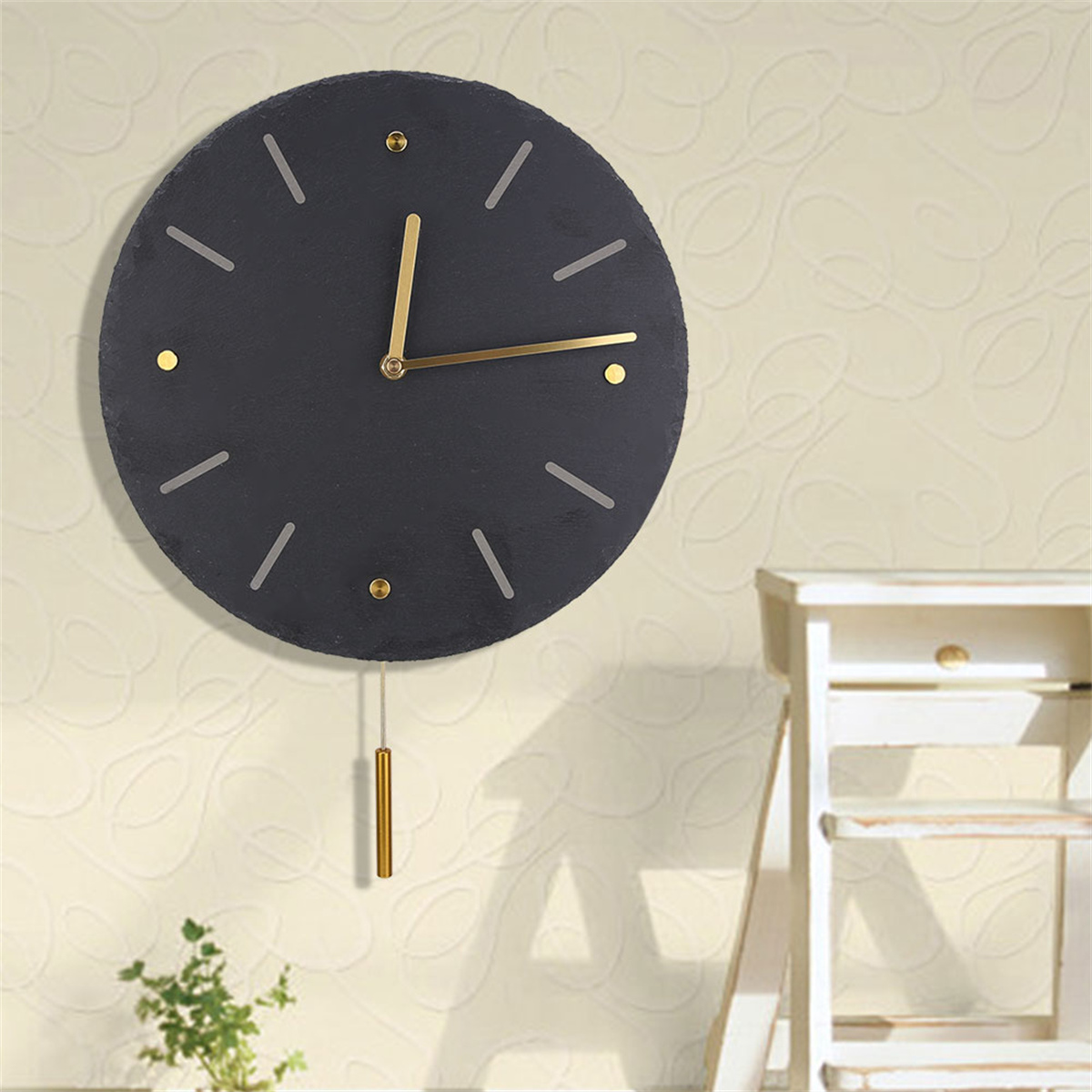 Schwarze Schieferuhr an der Wand mit goldenen Zeigern und Markierungen.