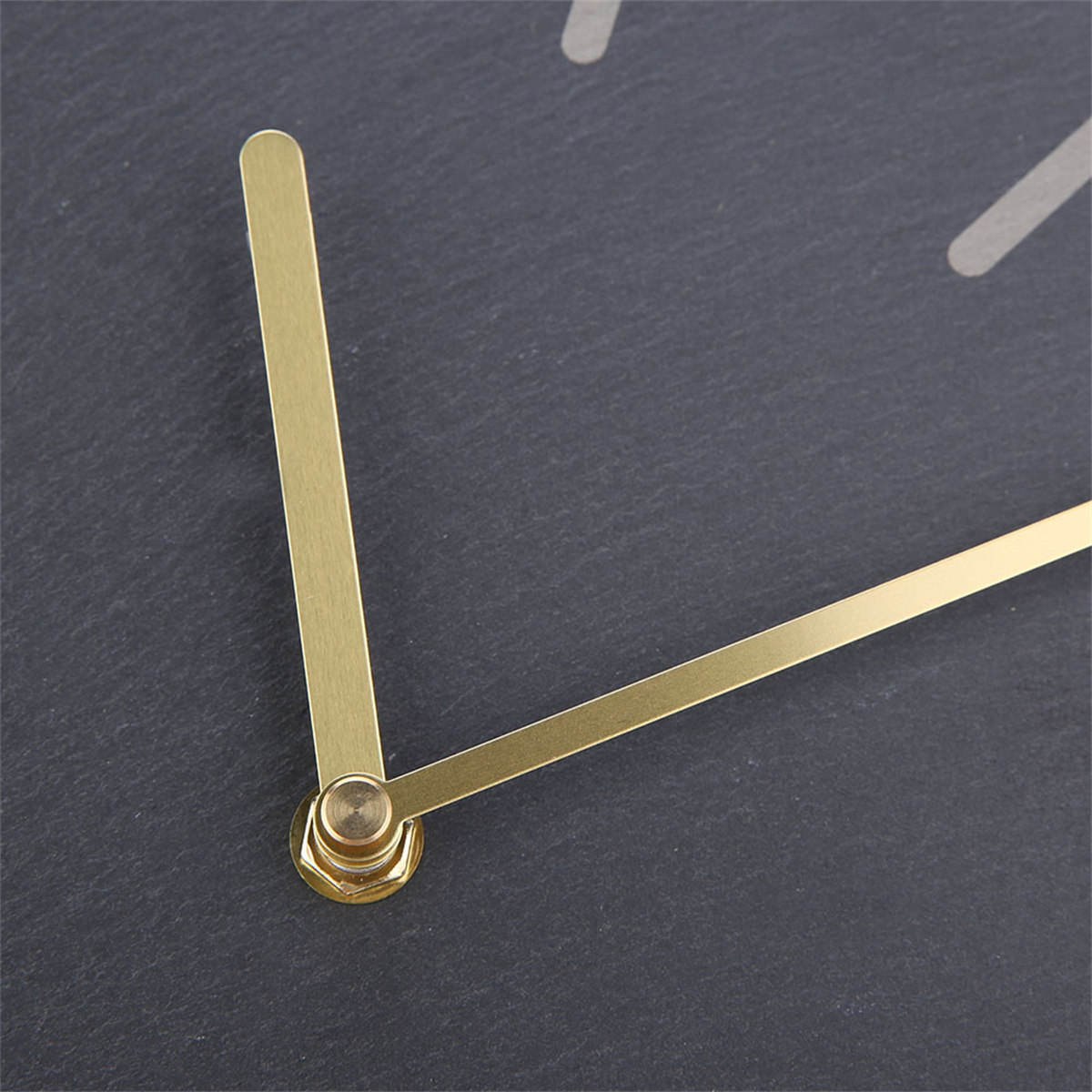 Nahaufnahme einer Uhr mit goldenen Zeigern auf dunklem grauem Hintergrund.