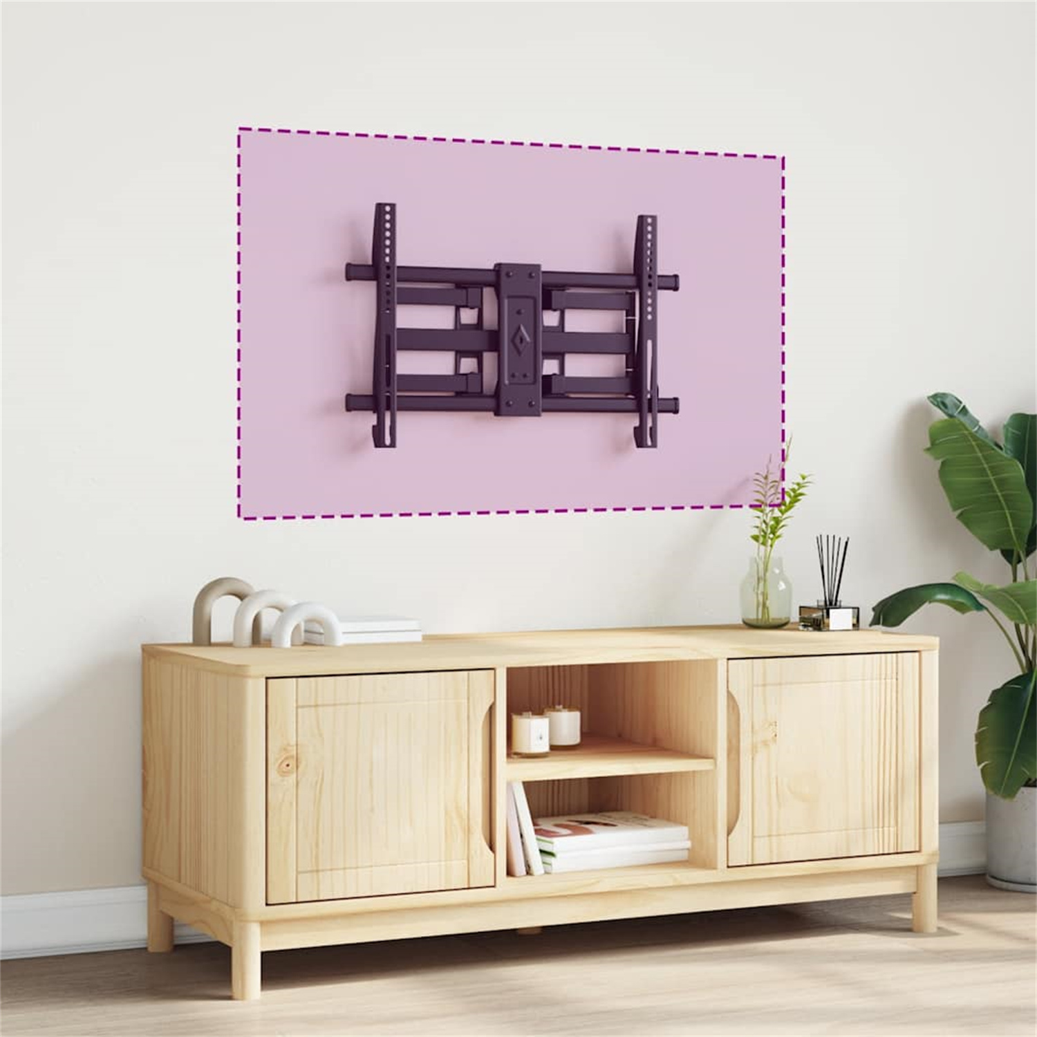 Eine TV-Wandhalterung an einer rosa Wand. Darunter ein Holzschrank mit Gegenständen.
