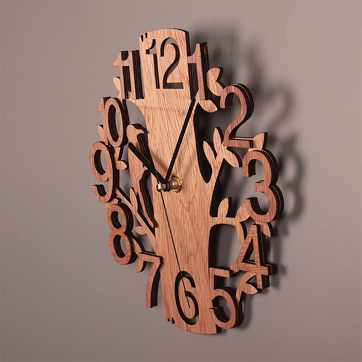 Baumförmige Uhr aus Holz mit schwarzen Zeigern, an einer grauen Wand.