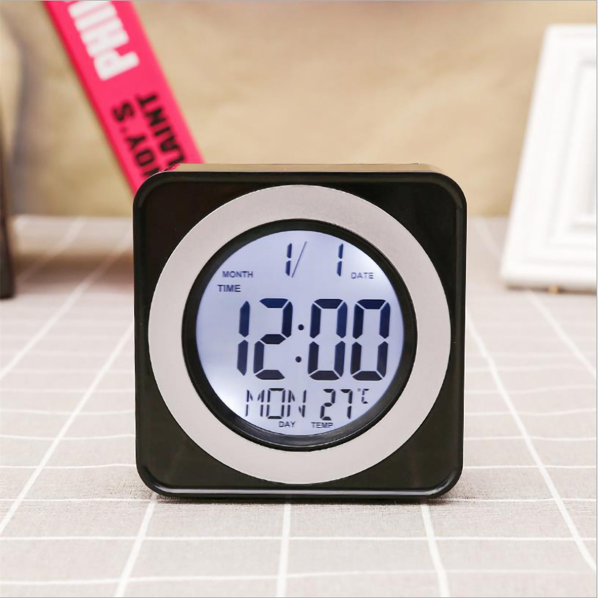 Eine kleine schwarze Digitaluhr, die Datum und Uhrzeit anzeigt.