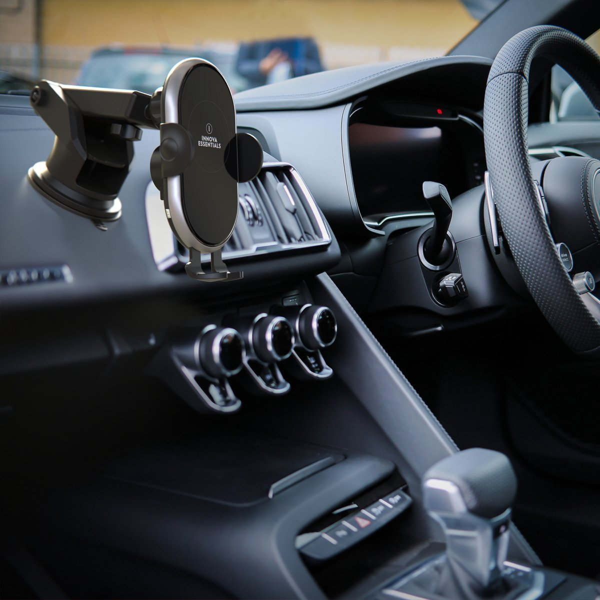 Autointerieur mit einer am Armaturenbrett befestigten Telefonhalterung. Lenkrad und Lüftungsschlitze sind ebenfalls sichtbar.