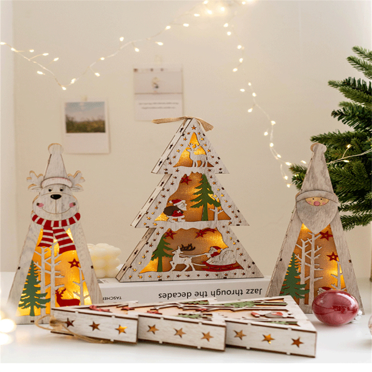 Weihnachtsdekorationen aus Holz: ein Rentier, ein Weihnachtsbaum und ein Weihnachtsmann. Lichter sind an.