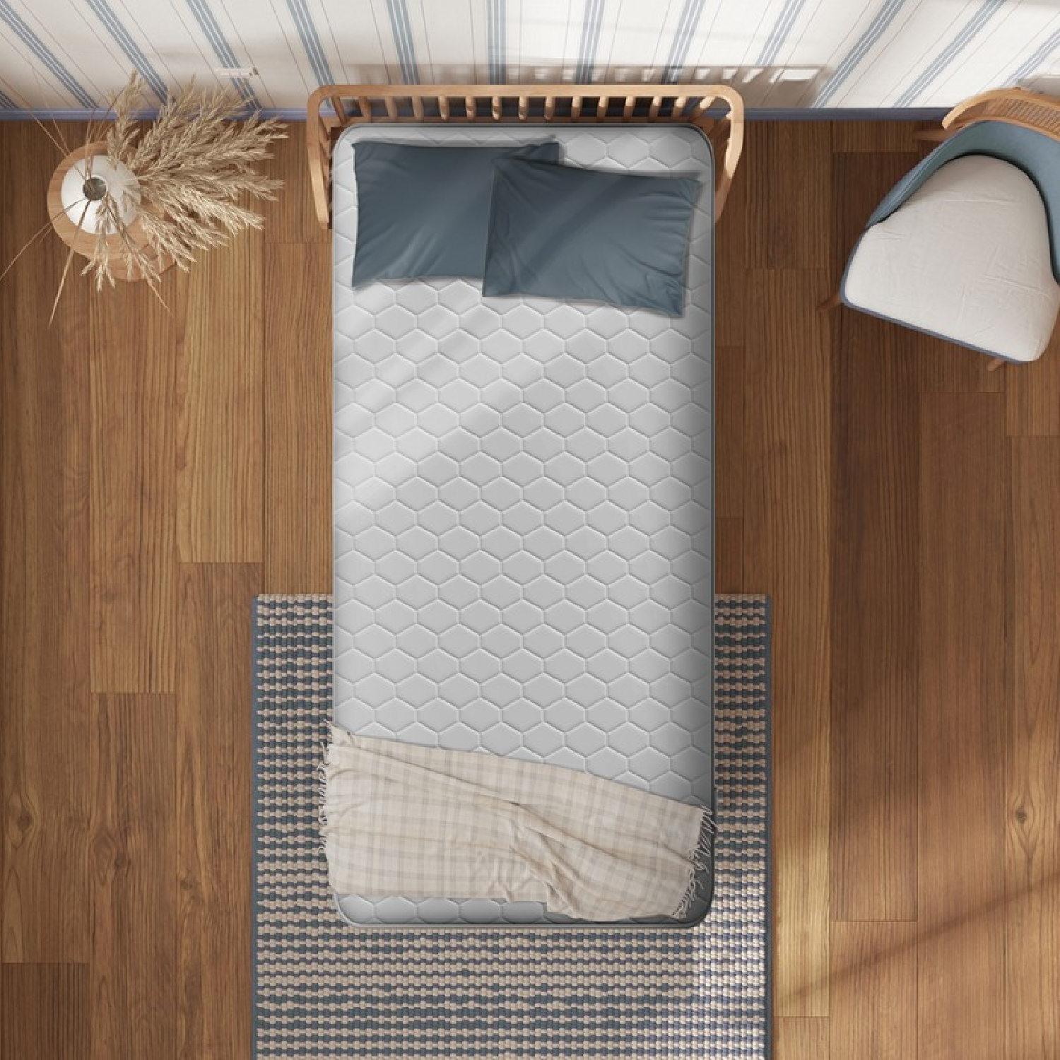 Bovenaanzicht van een bed met een grijze matras, twee kussens, een deken en een stoel.