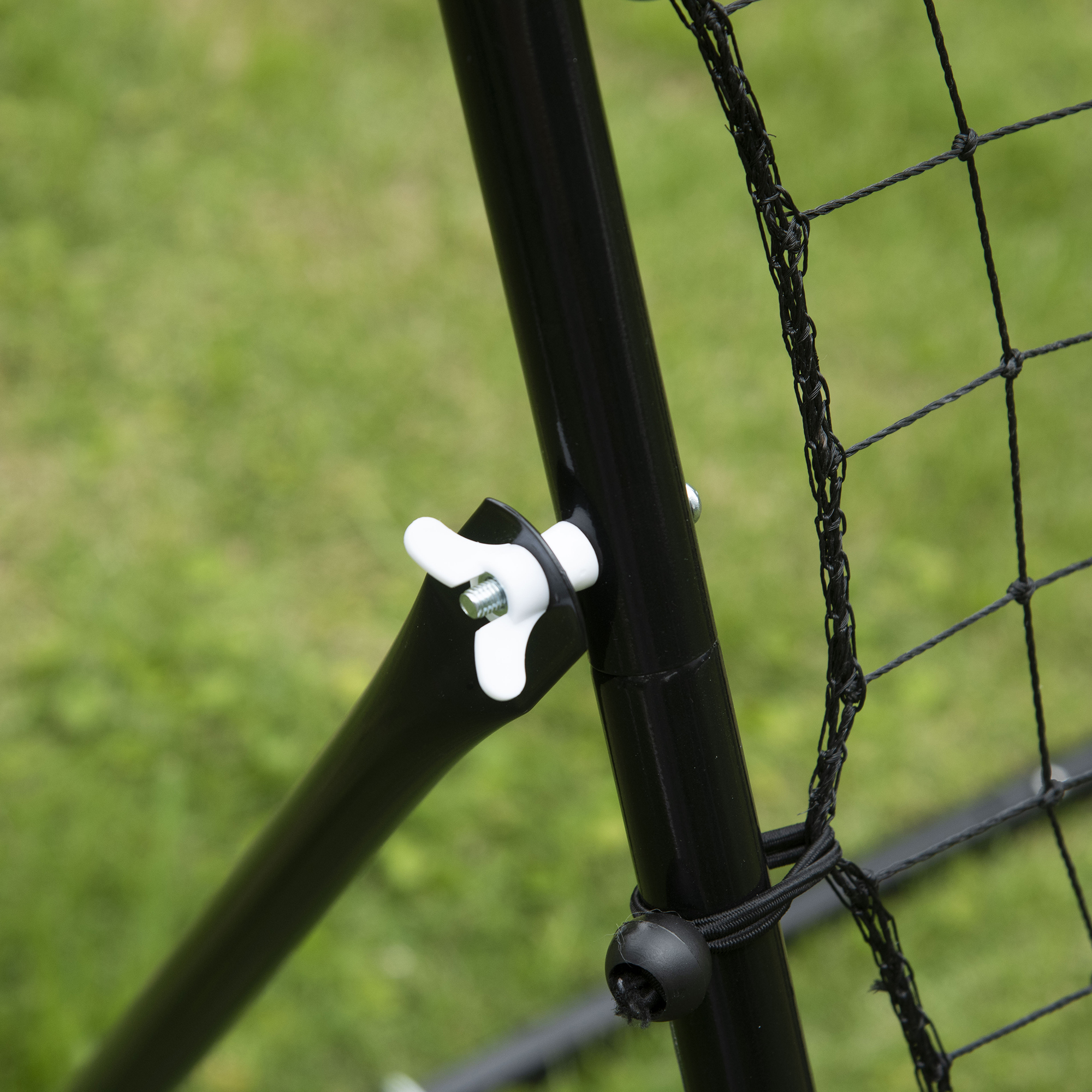 Primer plano de soporte de red de béisbol con mariposa blanca y barras negras.