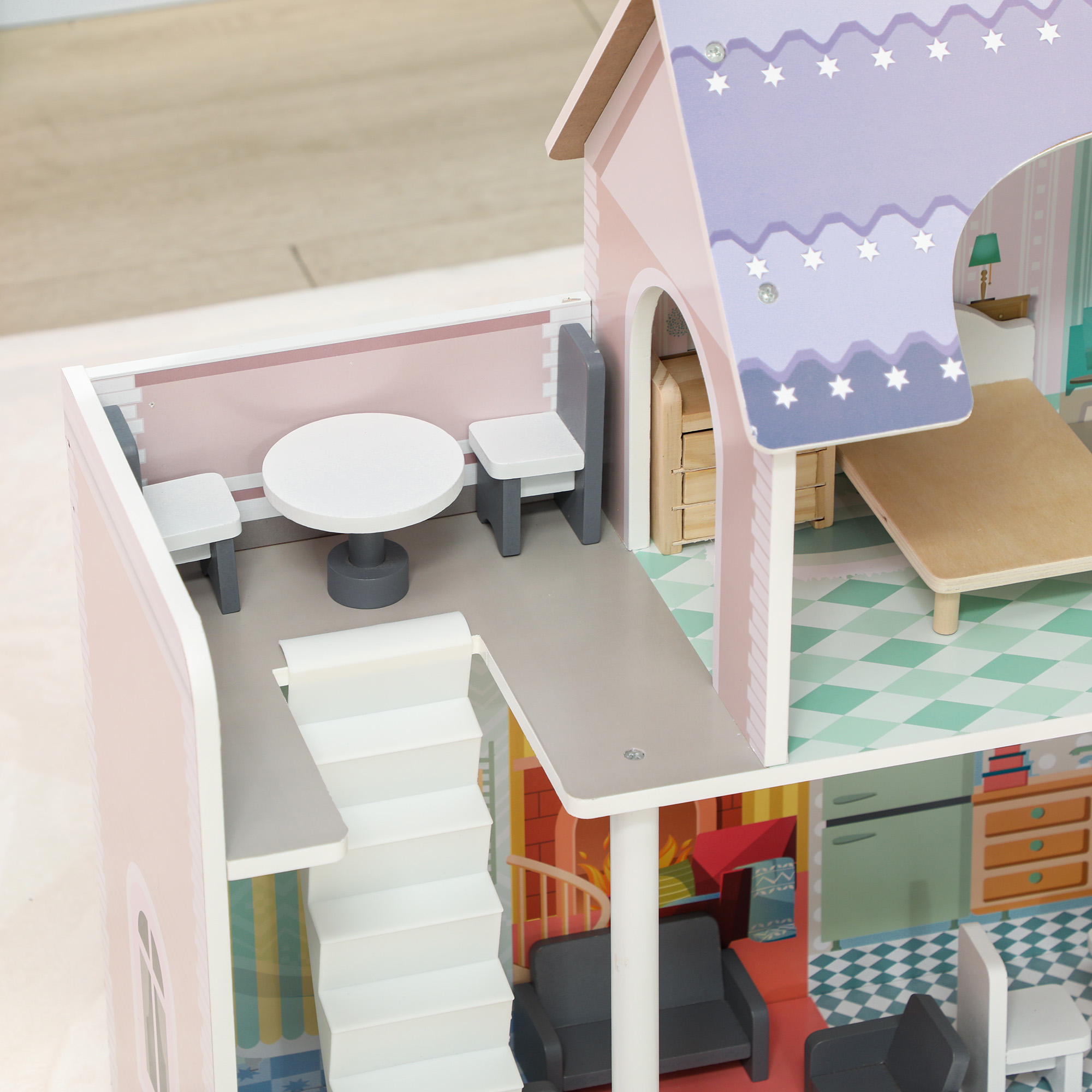 Vista detallada del interior de una casa de muñecas, mostrando escaleras, muebles y un exterior rosa con un interior claro.