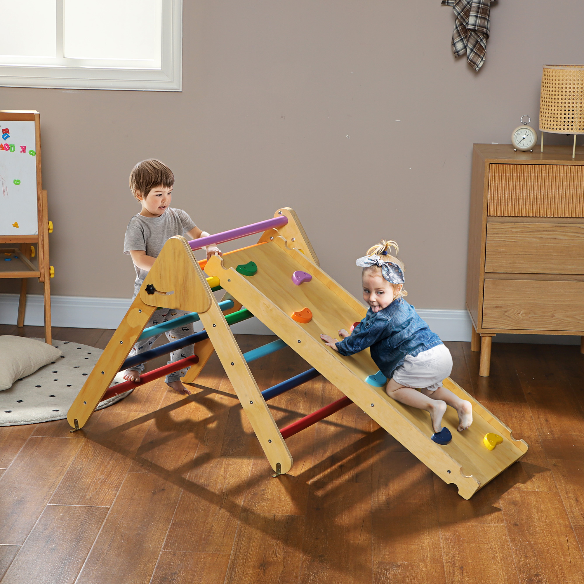 Dos niños jugando en una estructura de escalada de madera con presas de escalada coloridas.