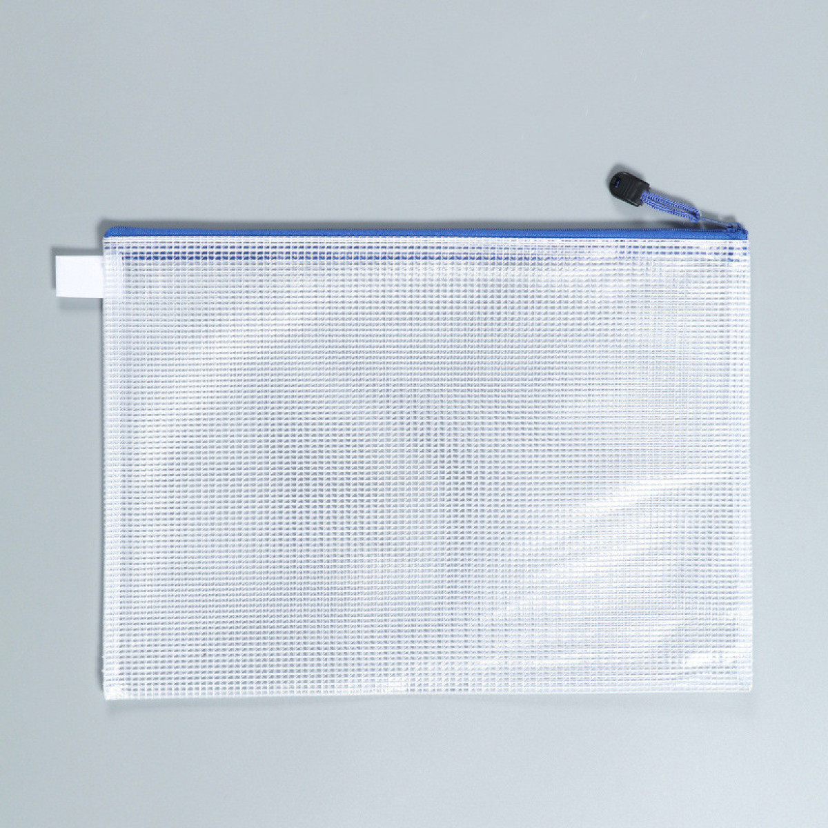 Transparante etui met ritssluiting en blauwe rand op grijze achtergrond. De etui is leeg en doorschijnend.