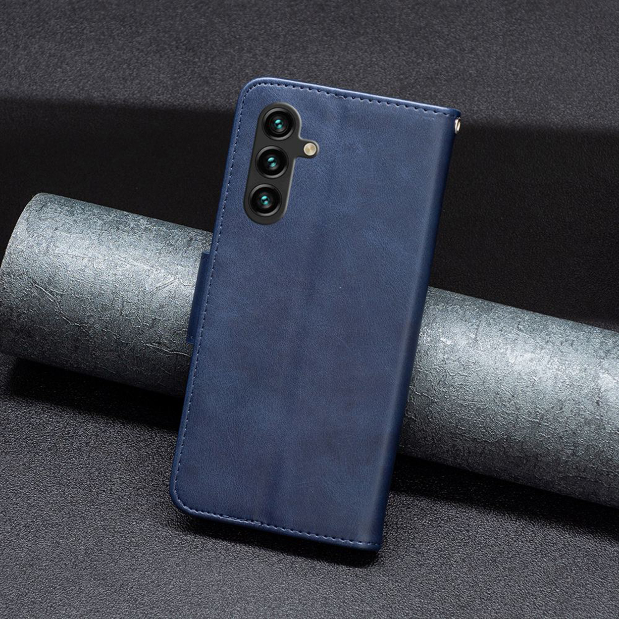 Blauwe telefoonhoes met een portemonnee-ontwerp, met de voorkant, achterkant en zijkant. De telefoon ligt op een donker oppervlak.
