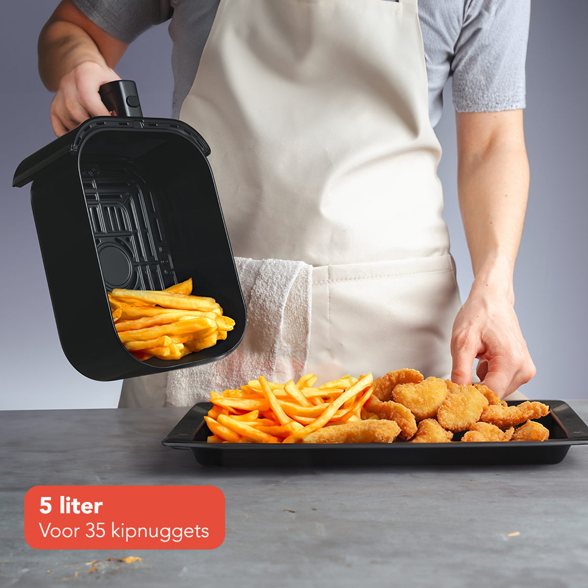 Personne tenant un panier de friteuse à air avec des frites, plateau de nuggets de poulet. Fond gris.