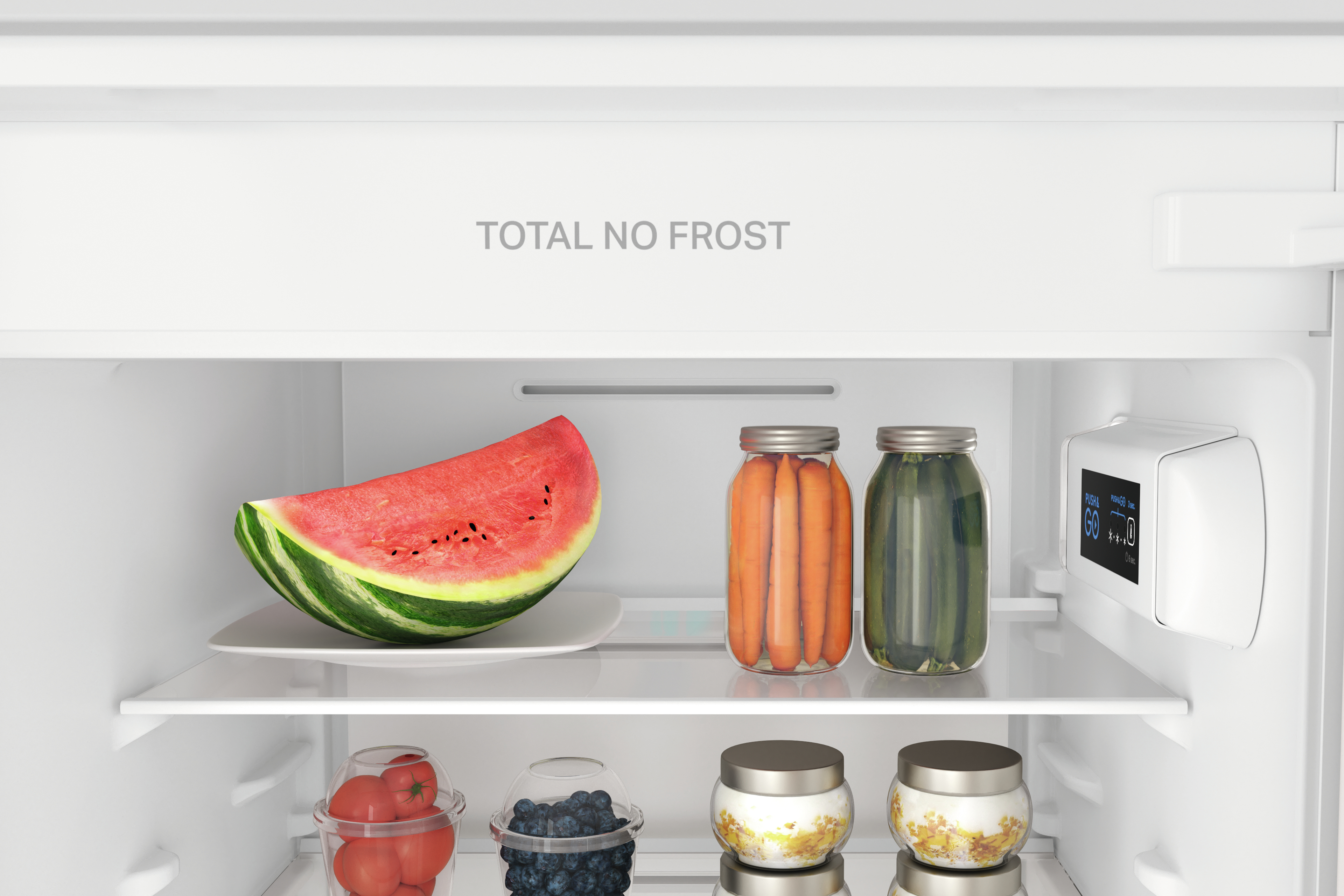 Wewnątrz lodówki. Widoczna arbuz, marchew i ogórki kiszone. Ponadto dwie półki z produktami spożywczymi.