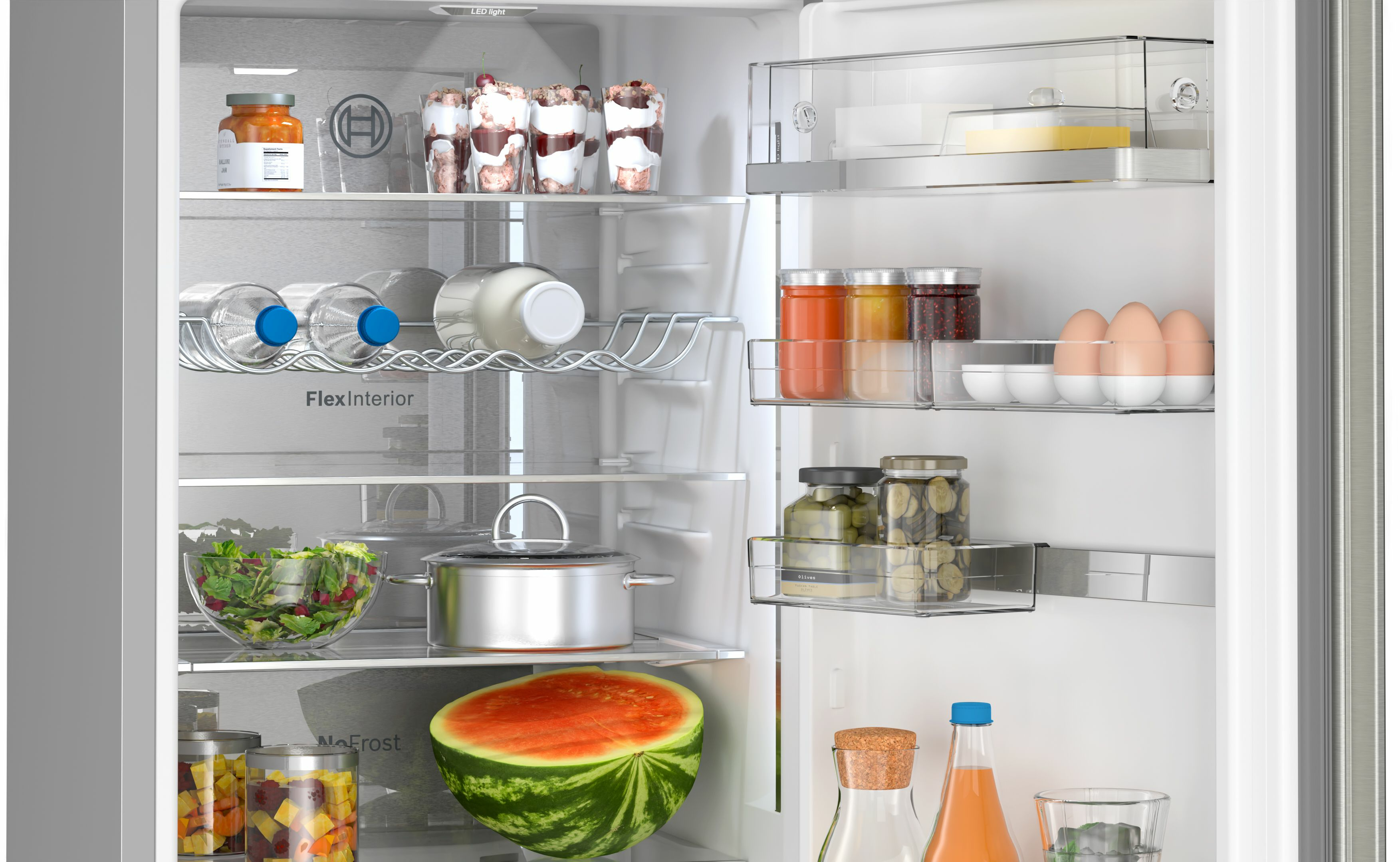 Dentro de un refrigerador, con estantes y contenido. Se ven alimentos, bebidas y recipientes.