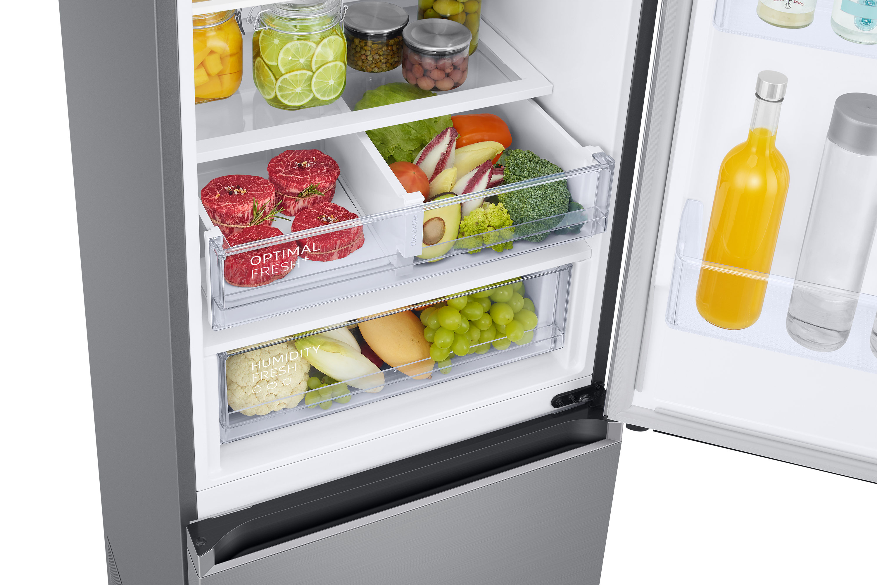 Kühlschrankinnenraum mit Schubladen mit Lebensmitteln: Fleisch, Gemüse, Obst und Saft.
