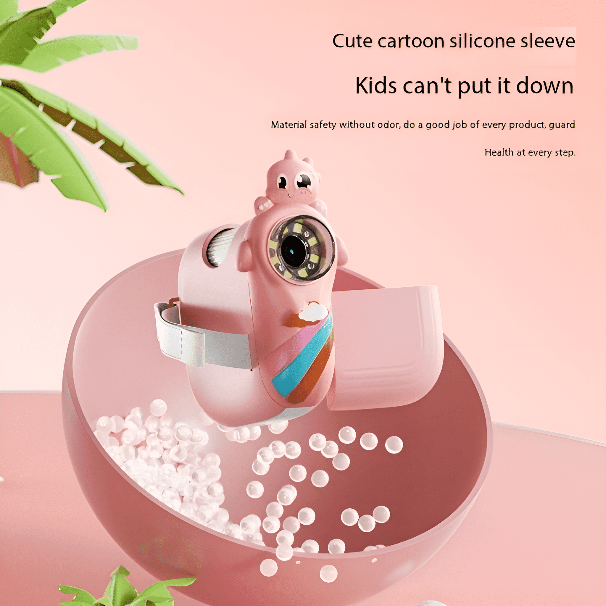 Ein rosa Spielzeugkamera in einer rosa Schüssel mit weißen Kugeln. Die Kamera hat ein Cartoon-Gesicht und Regenbogenmuster.