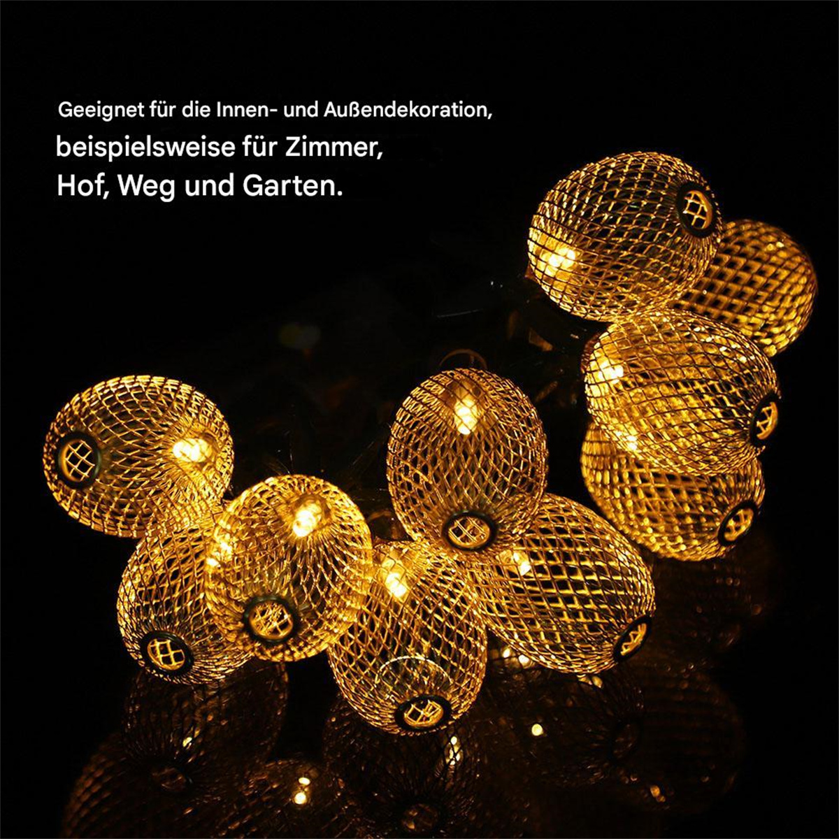 Goldene kugelförmige Lichterketten mit schwarzem Hintergrund. Die Lichter sind beleuchtet.