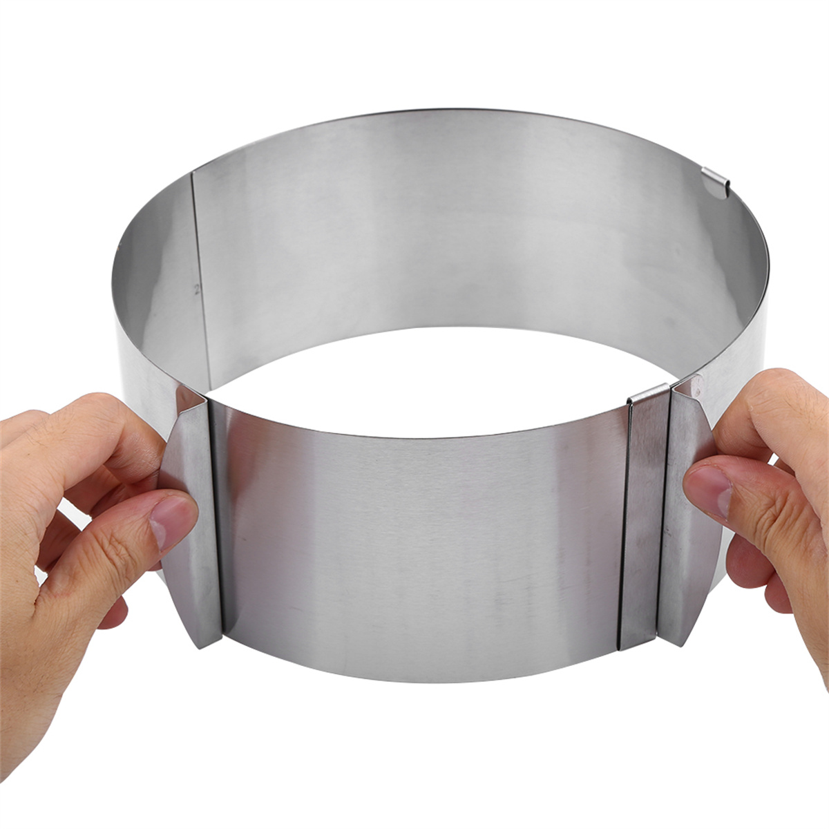 Zwei Hände halten einen silbernen Kuchenring. Der Ring ist für verschiedene Kuchengrößen einstellbar.