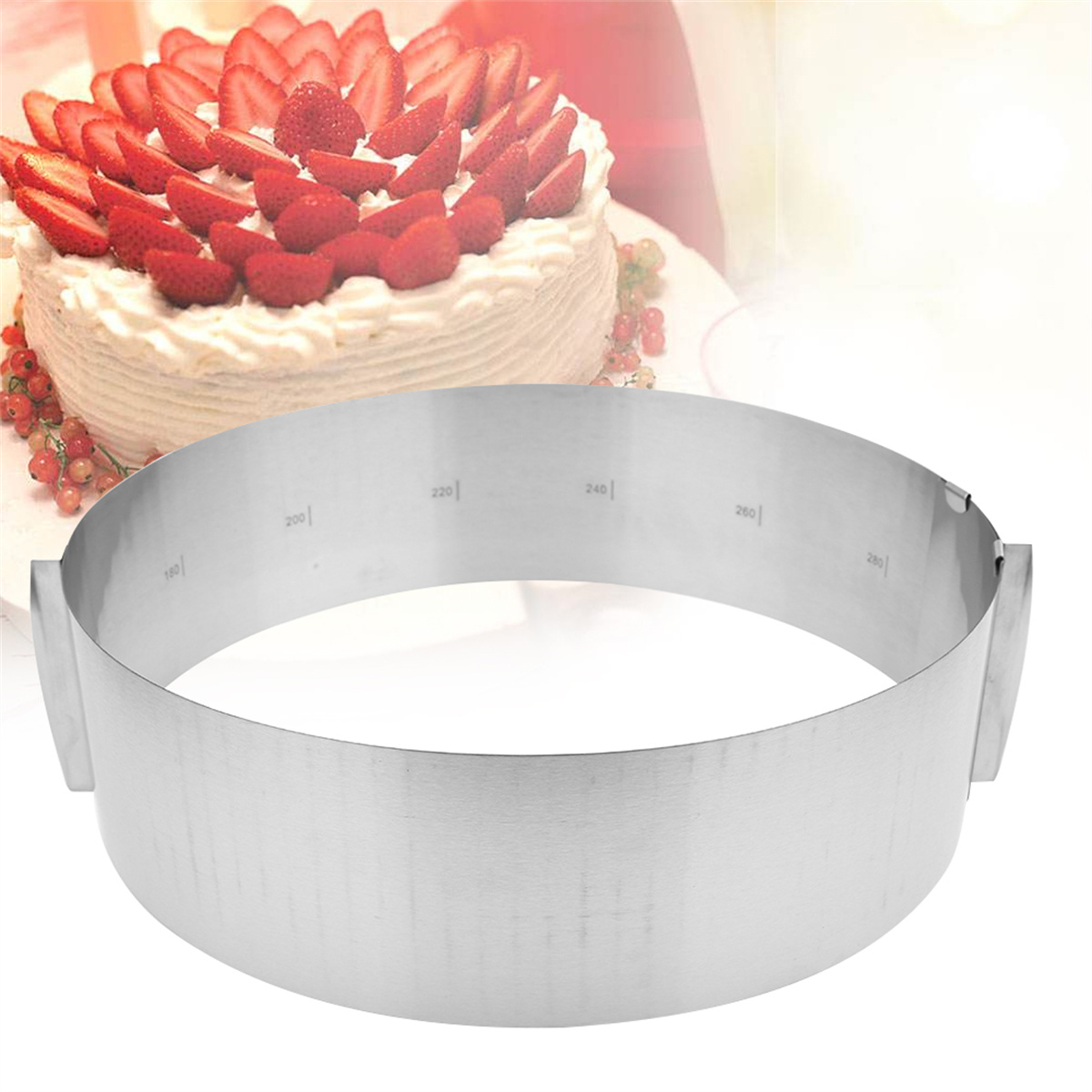Ein Kuchenring aus Edelstahl mit einem Kuchen mit Erdbeeren im Hintergrund.