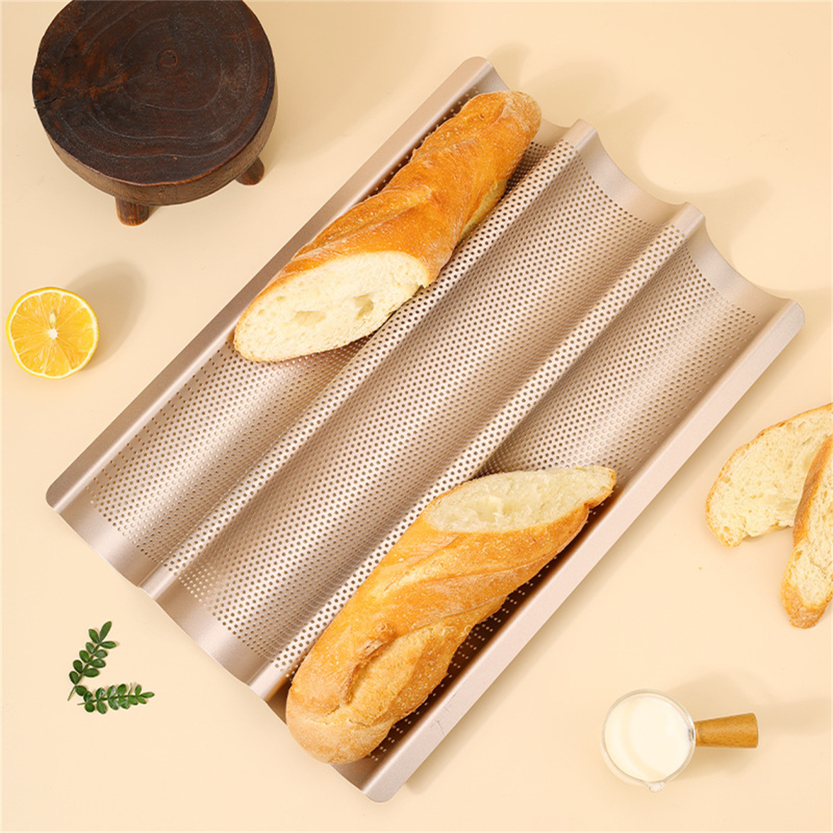 Baguettes auf einem Backblech. Das Blech hat Löcher. Zitrone und Tasse daneben.