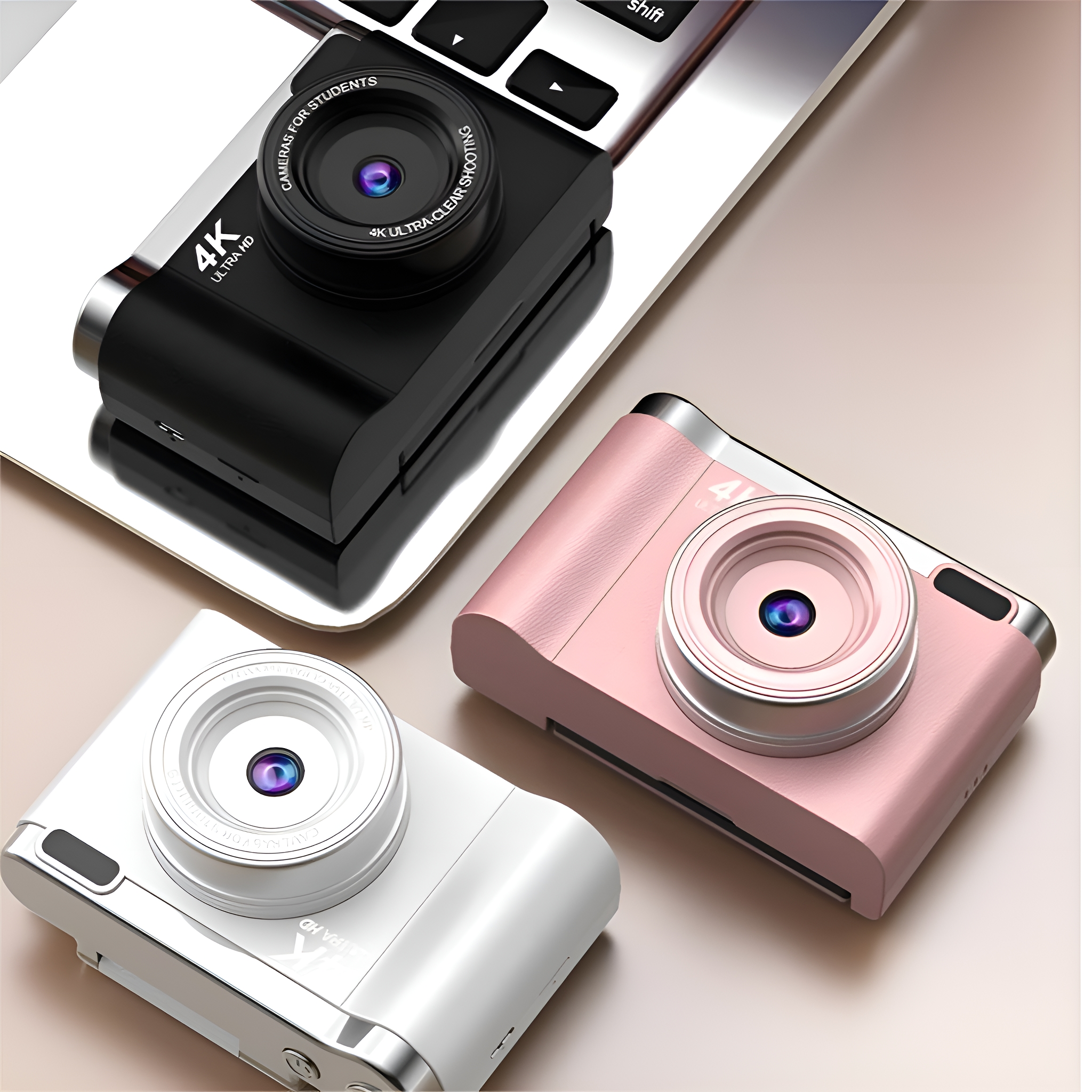 Drei Kameras. Eine schwarze auf einem Laptop, eine weiße und eine rosa. 4K ULTRA HD. Kameras für Schüler.