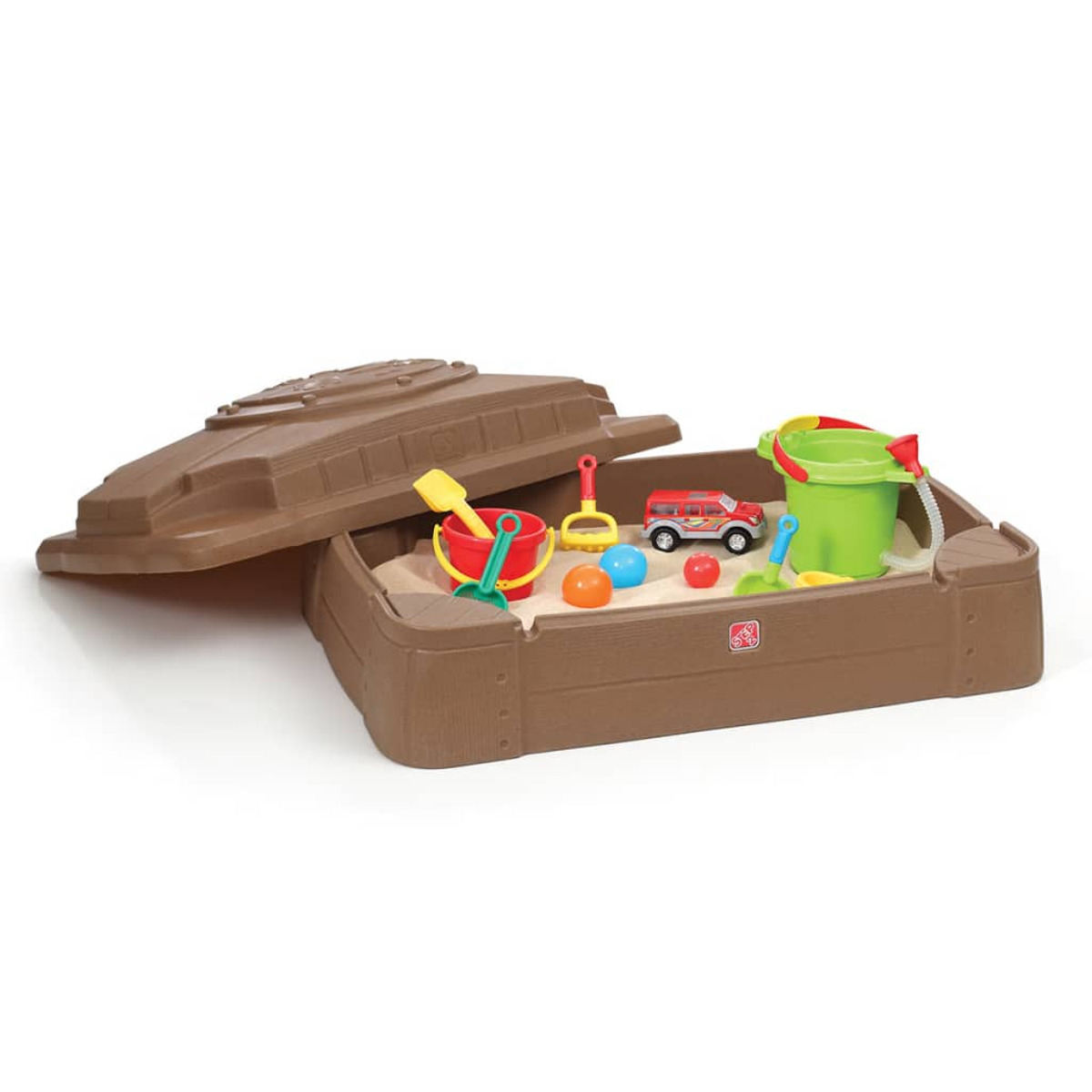 Eine braune Sandkiste mit Spielzeug. Enthält einen roten Eimer, Schaufeln, Bälle, einen roten Bus und einen grünen Eimer. Der Deckel ist offen.