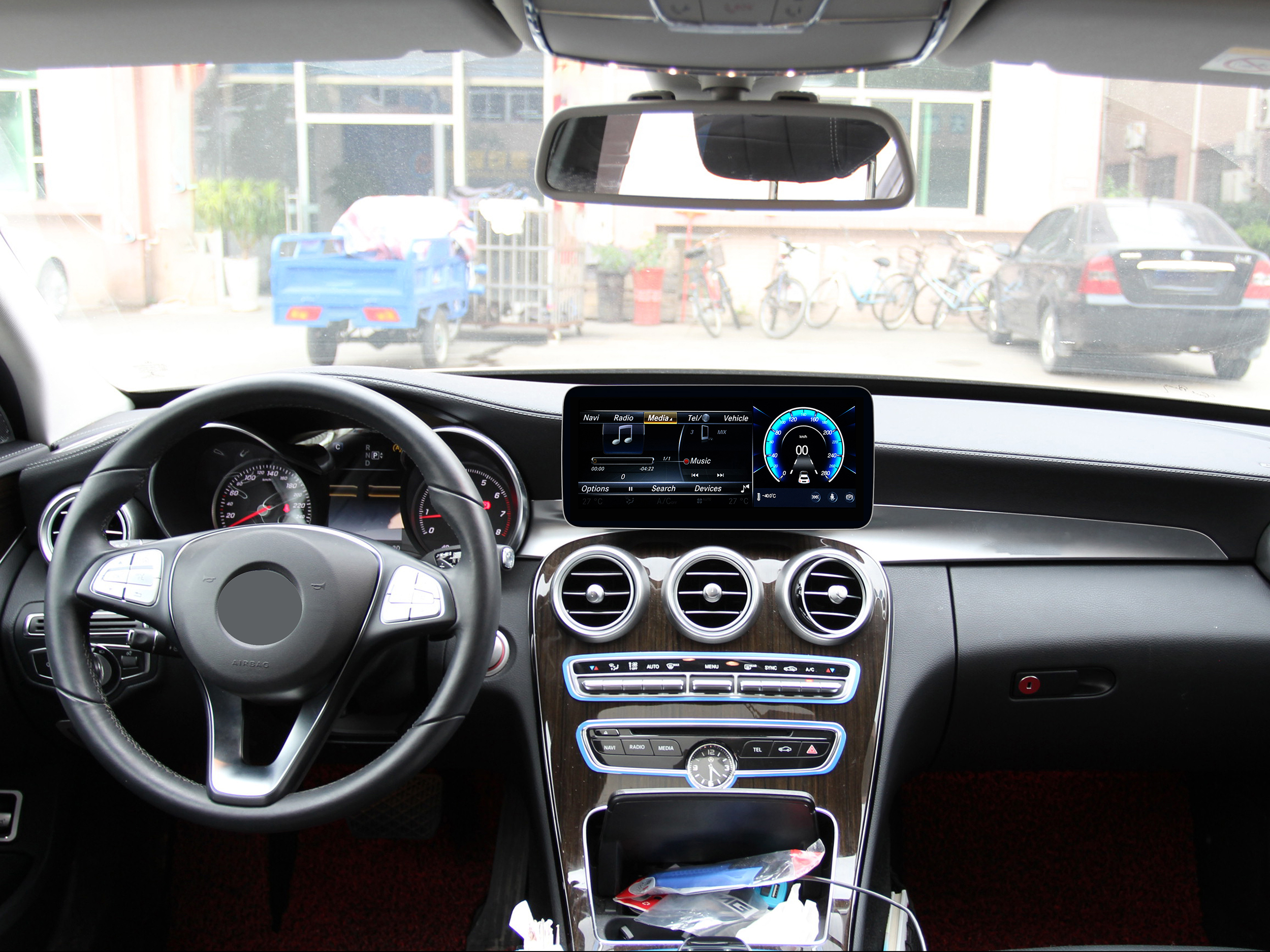 Auto-Innenraum-Armaturenbrett. Zeigt einen Bildschirm mit Musikinfo und Tachometer. Lenkrad sichtbar.