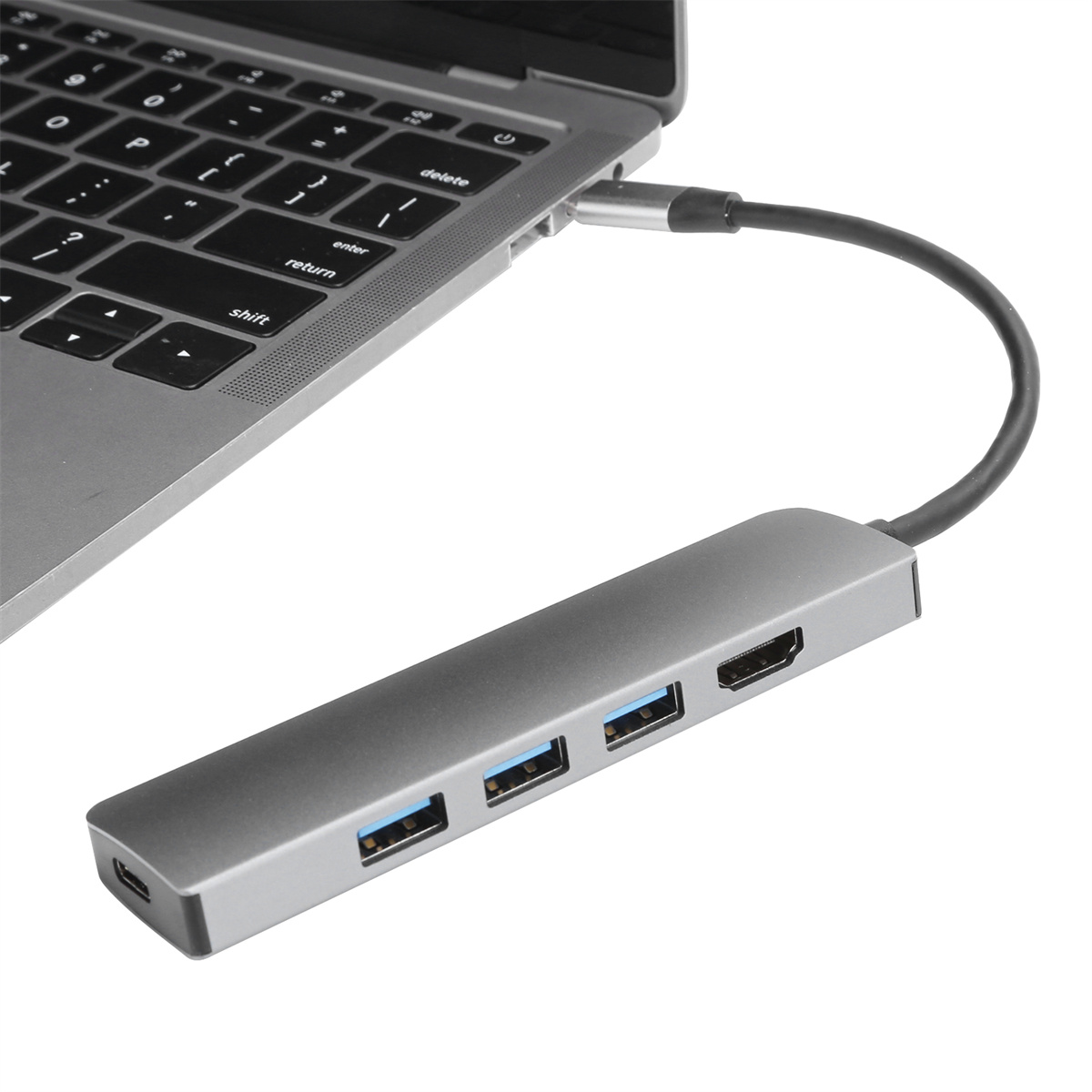 Laptop mit einem grauen USB-Hub mit USB- und HDMI-Anschlüssen verbunden.
