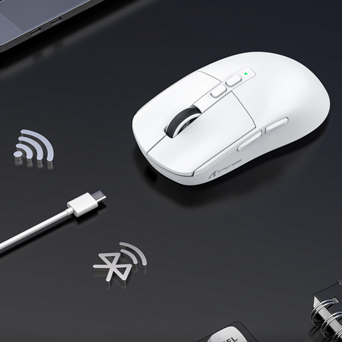Eine weiße kabellose Maus mit Tasten, einem Scrollrad und einem USB-Kabel in der Nähe.