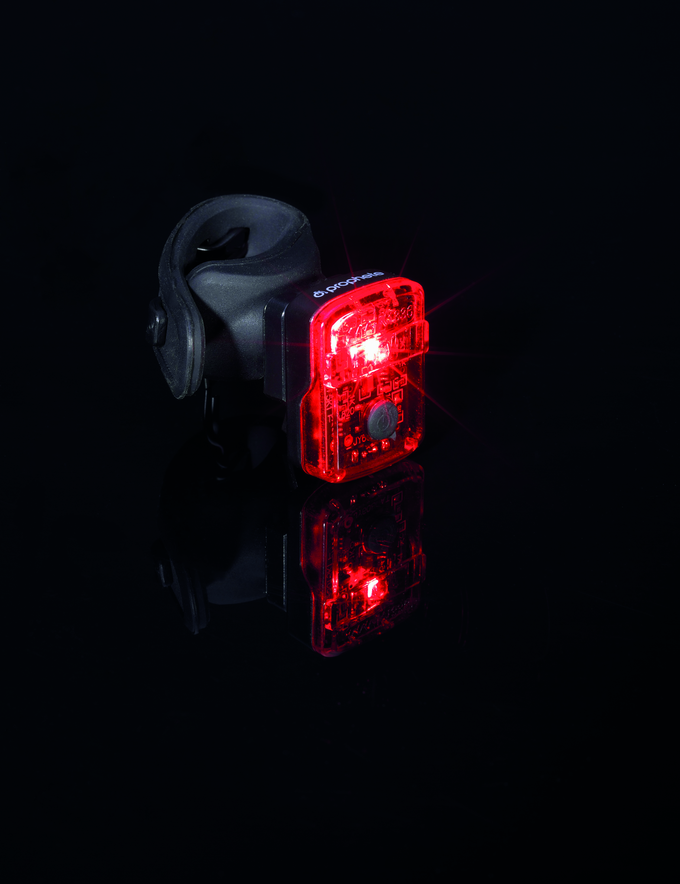 Rotes Fahrradlicht auf schwarzem Hintergrund. Das Licht leuchtet.