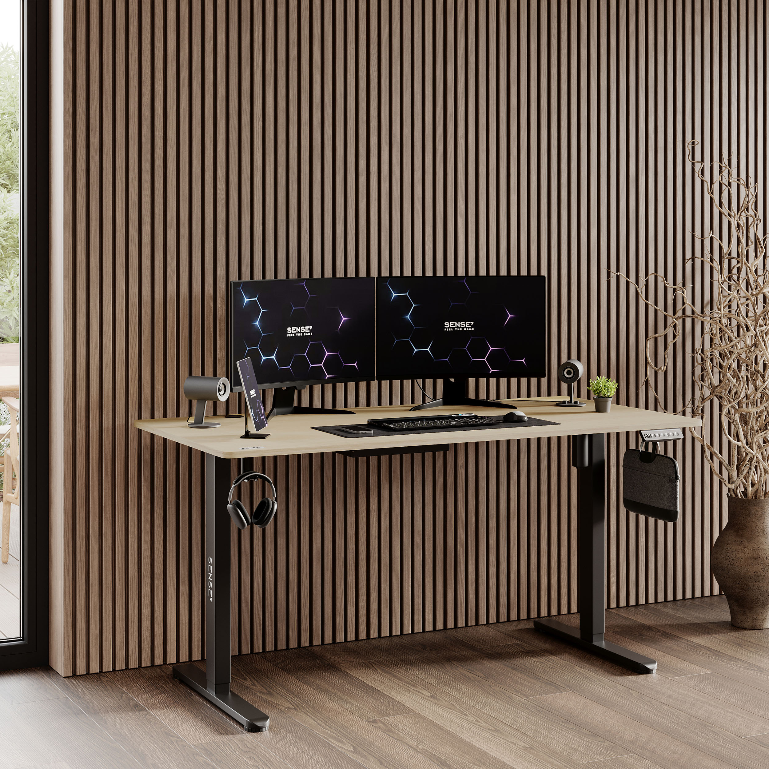 Een kamer met een bureau, twee monitoren, een telefoon en een koptelefoon. Er is een plant en een vaas op de achtergrond.