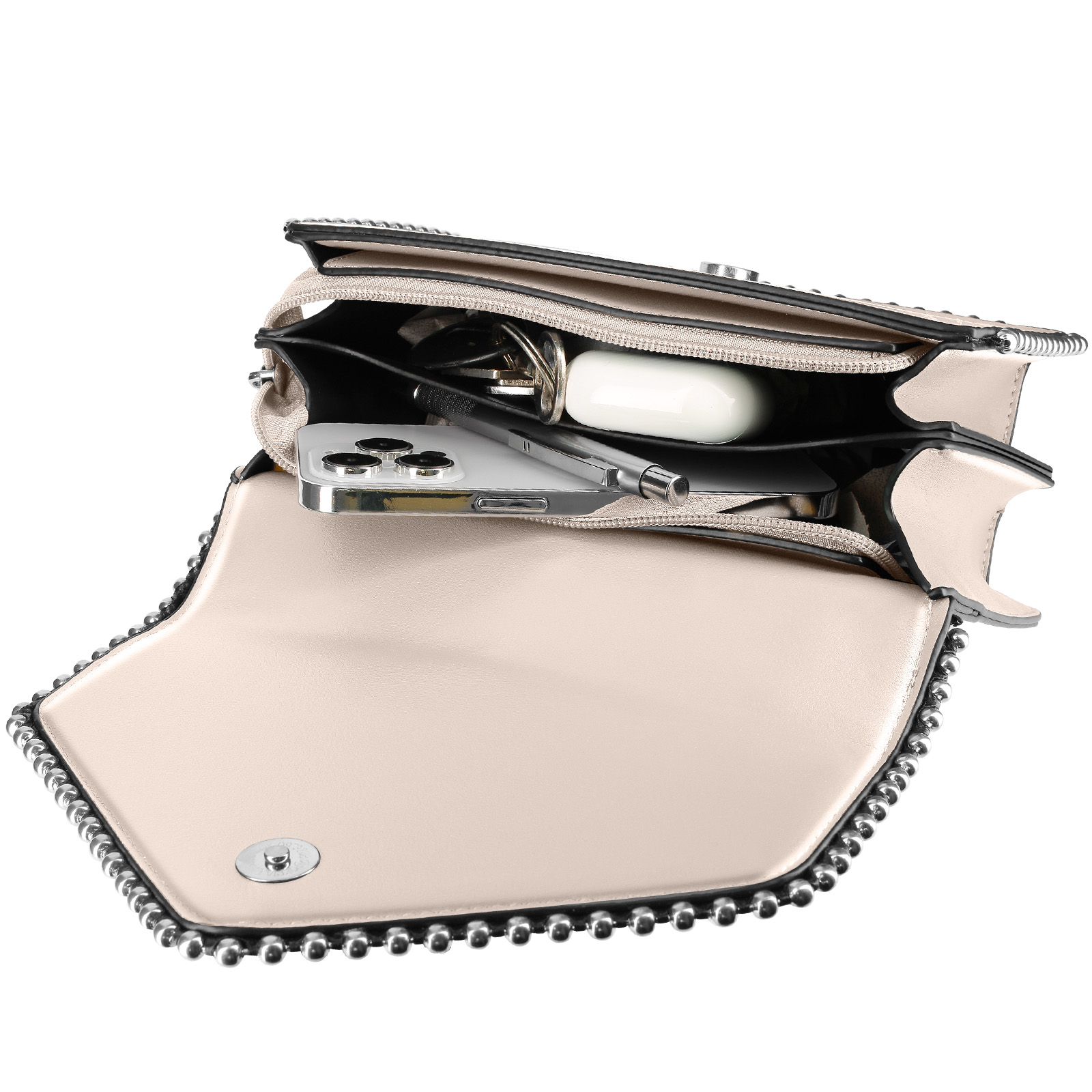 Offene beige Handtasche mit Telefon, Schlüsseln und Kopfhörern sichtbar. Die Handtasche hat einen silbernen Nietenbesatz.