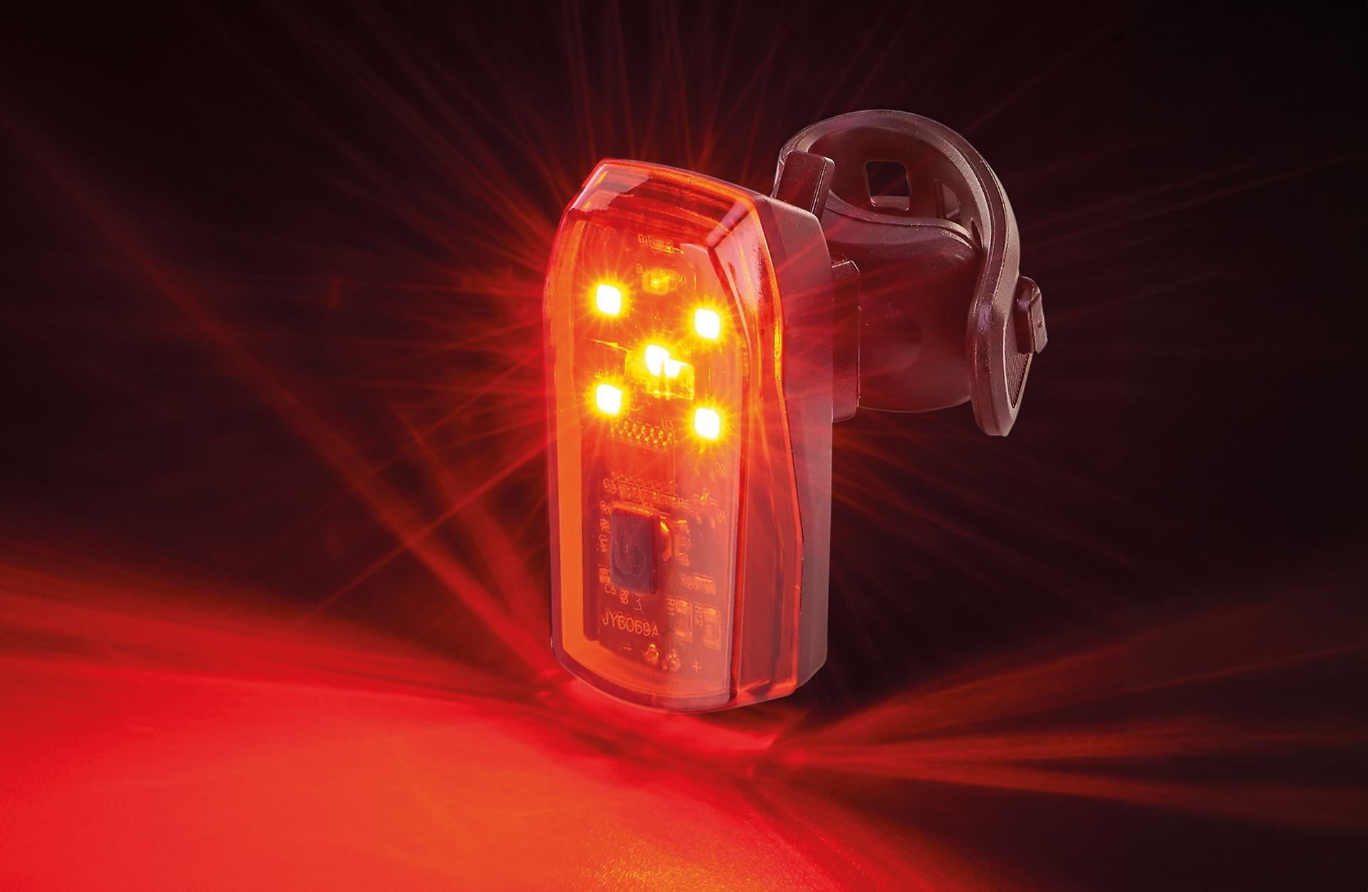 Rotes Fahrrad-Rücklicht mit mehreren hellen LEDs, auf dunklem Hintergrund.