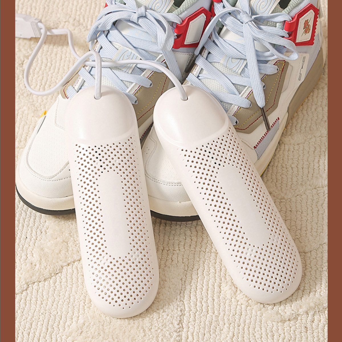 Asciugascarpe bianchi e scarpe da ginnastica. Gli asciugatori sono posizionati vicino alle scarpe.
